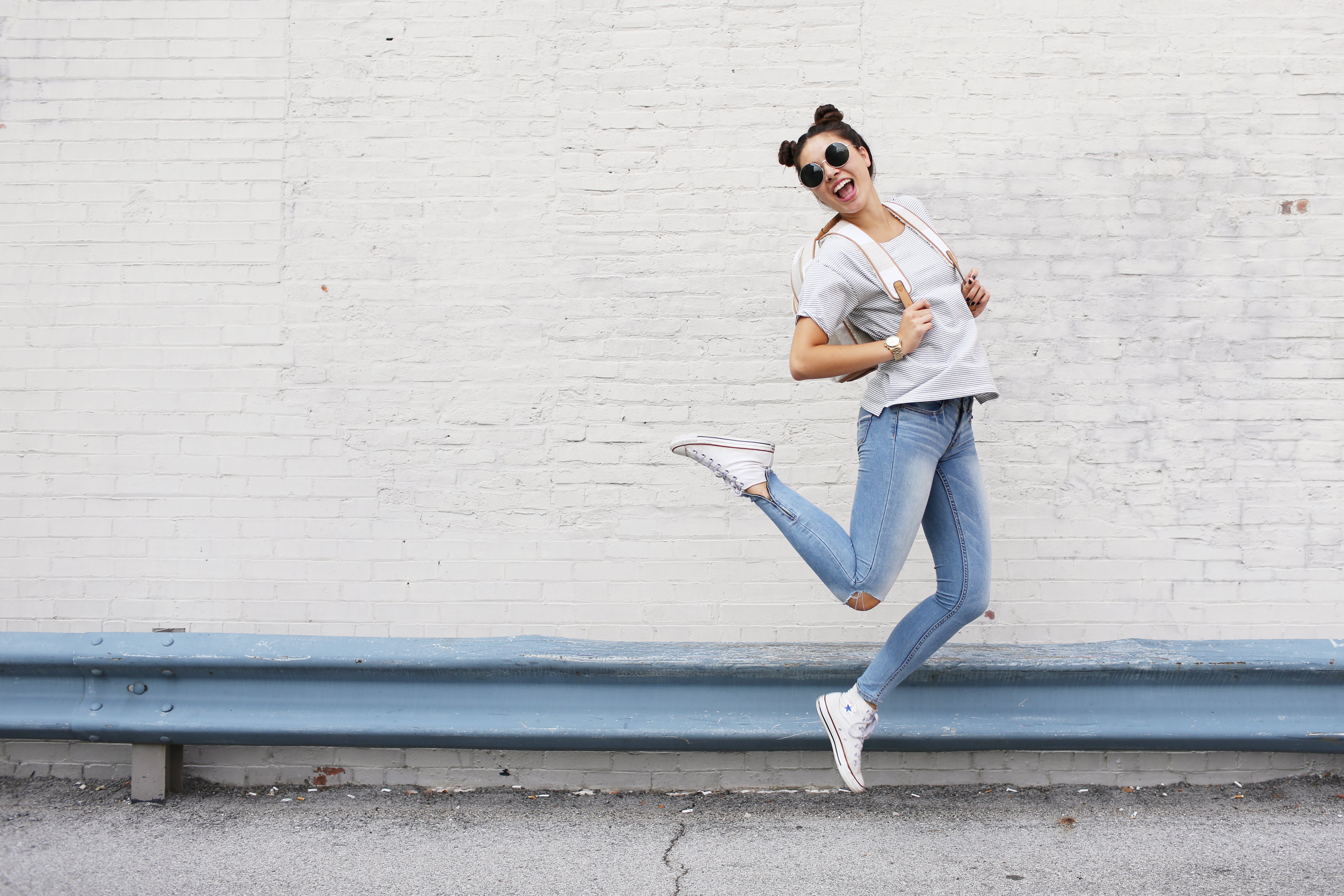 girl sunglasses jumping backback converse happy