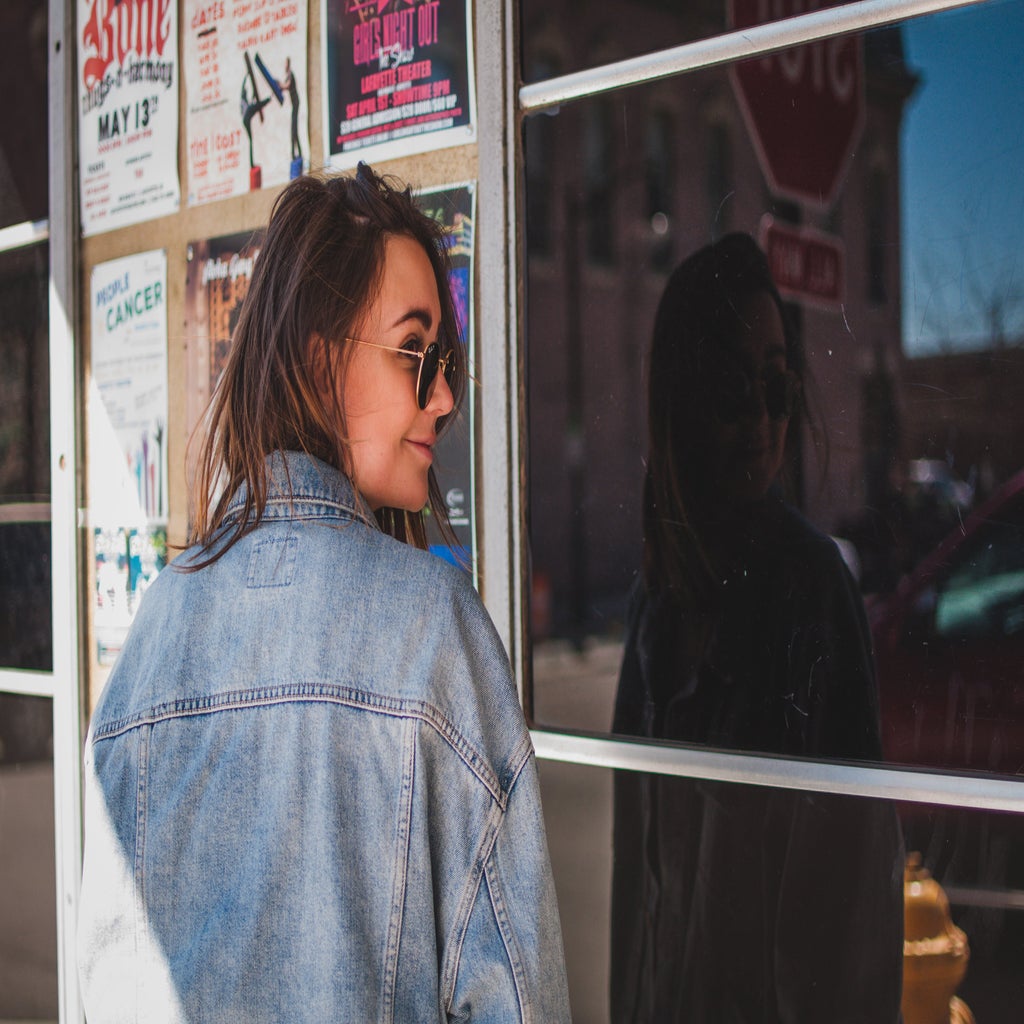 girl with jean jacket in front of shop