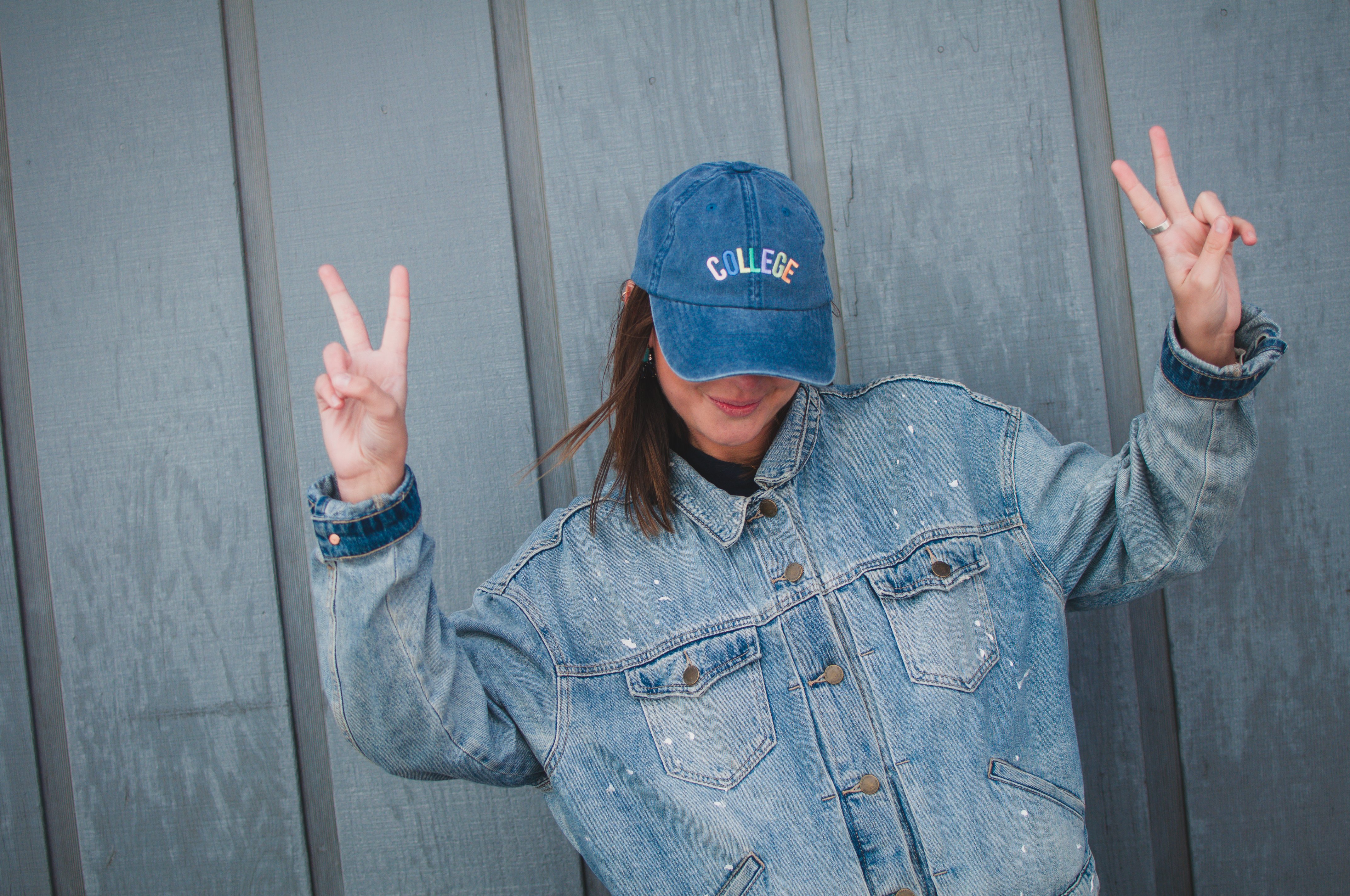 taylor thoman girl with jean jacket and collge hat peace sign?width=698&height=466&fit=crop&auto=webp&dpr=4