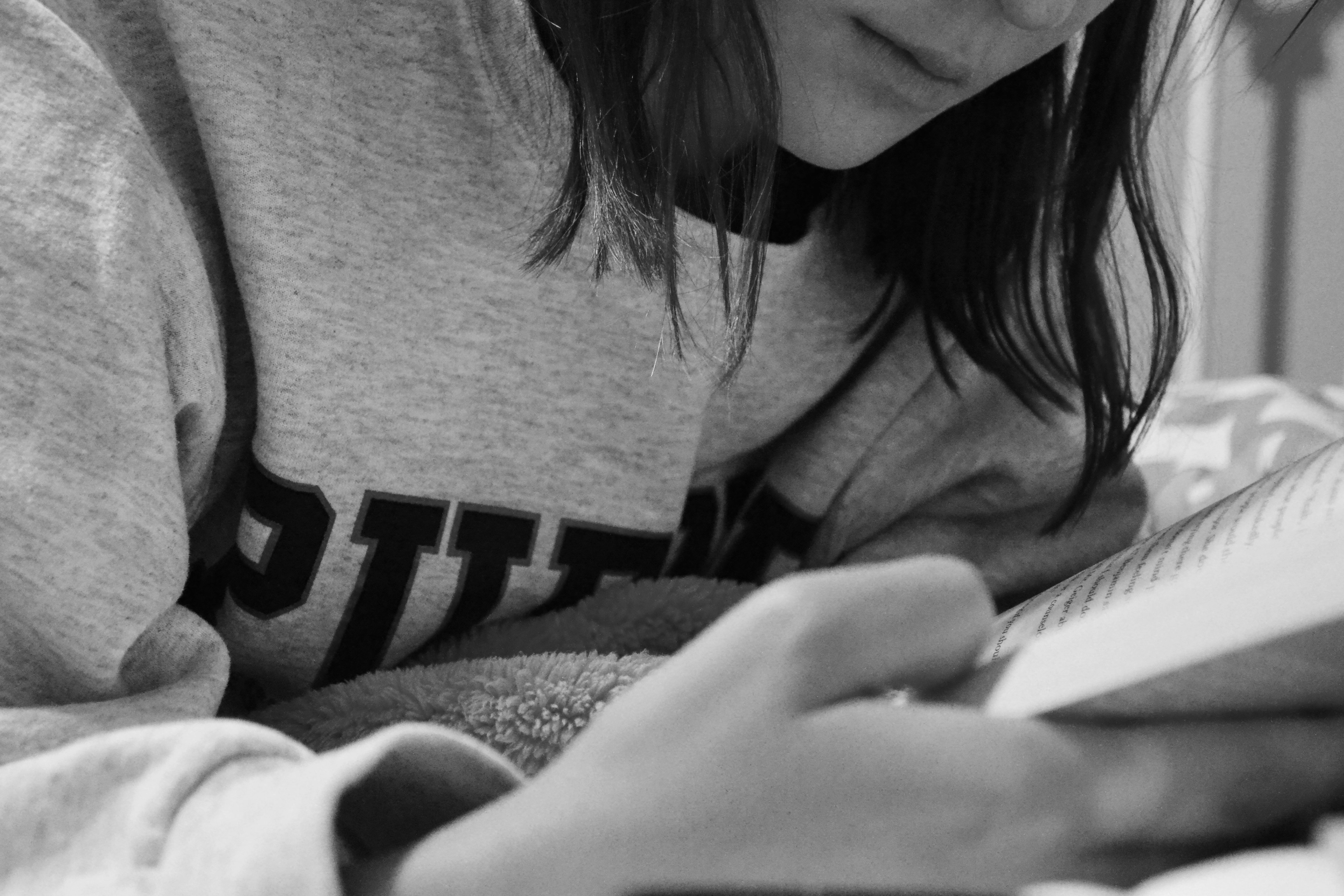 Girl Reading A Book In Bed