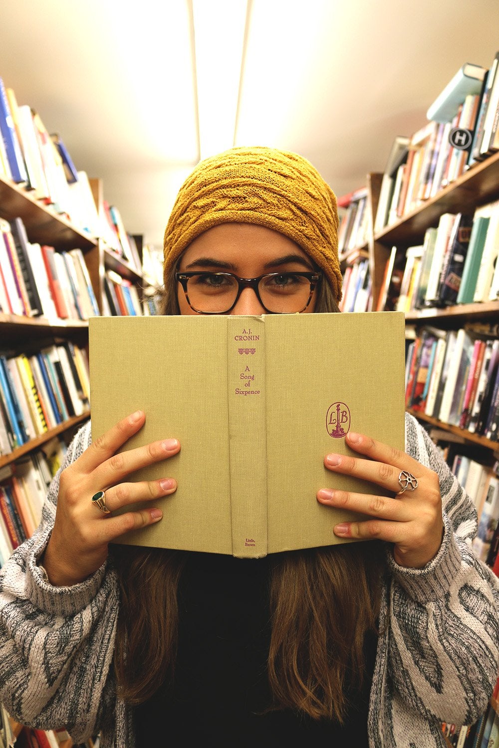 The Lalagirl With Beanie Holding Book Up