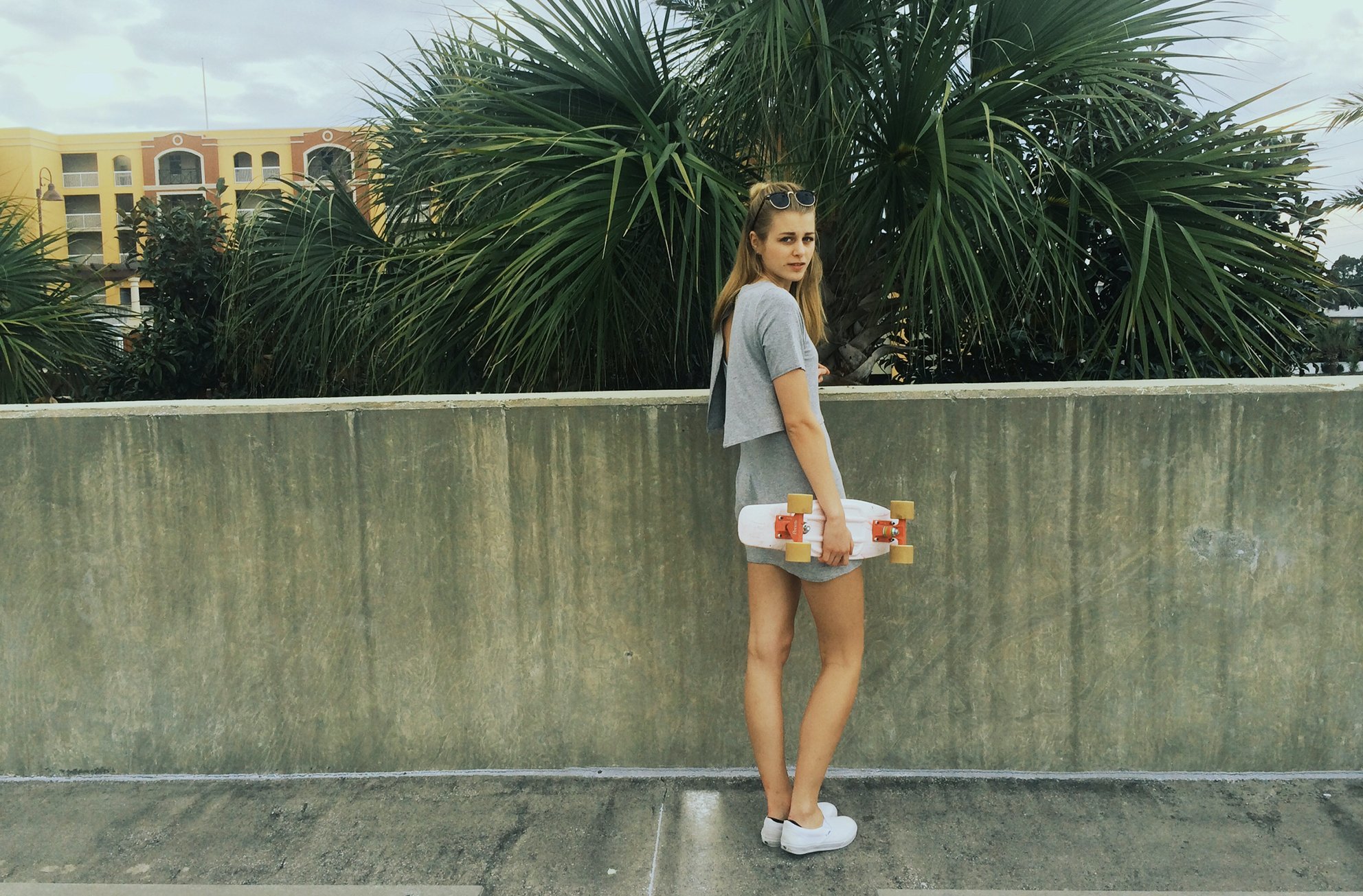 Anna Schultz-Girl Holding Penny Board Next To Palm Trees