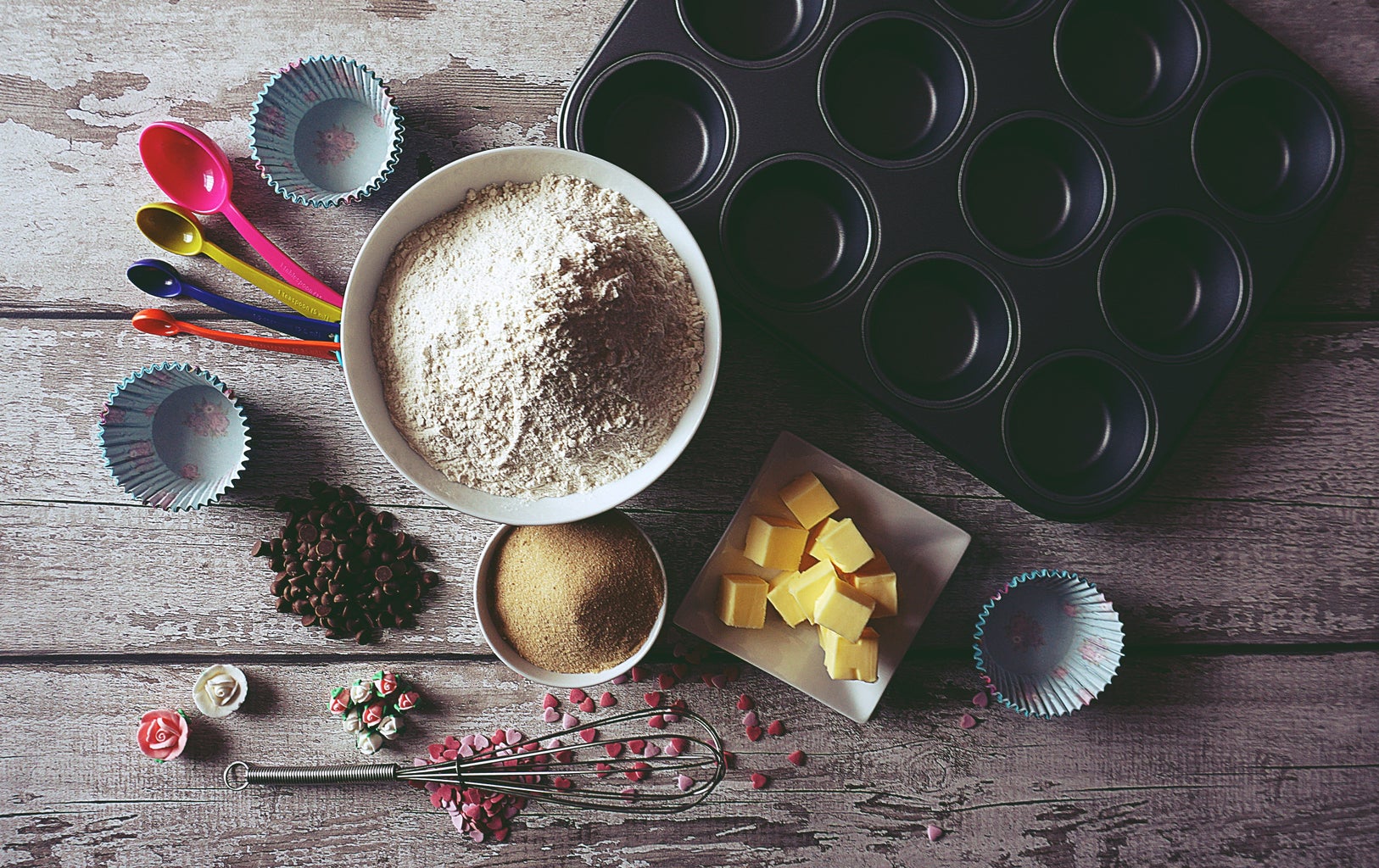 baking ingredients on a table next to a cupcake tray