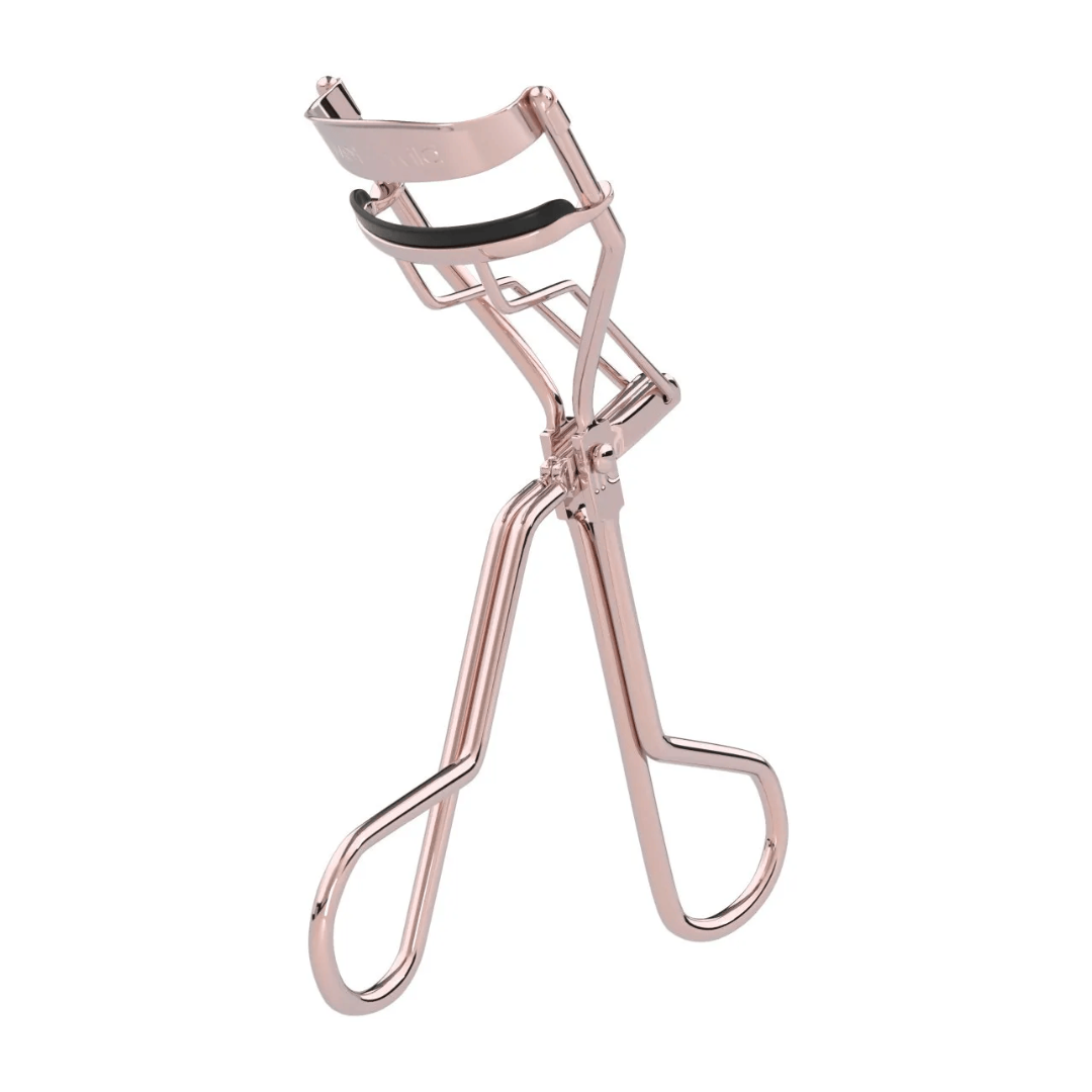 Rose gold eyelash curler with black rubber padding, featuring sleek curves and ergonomic handles, exuding a modern, elegant design.