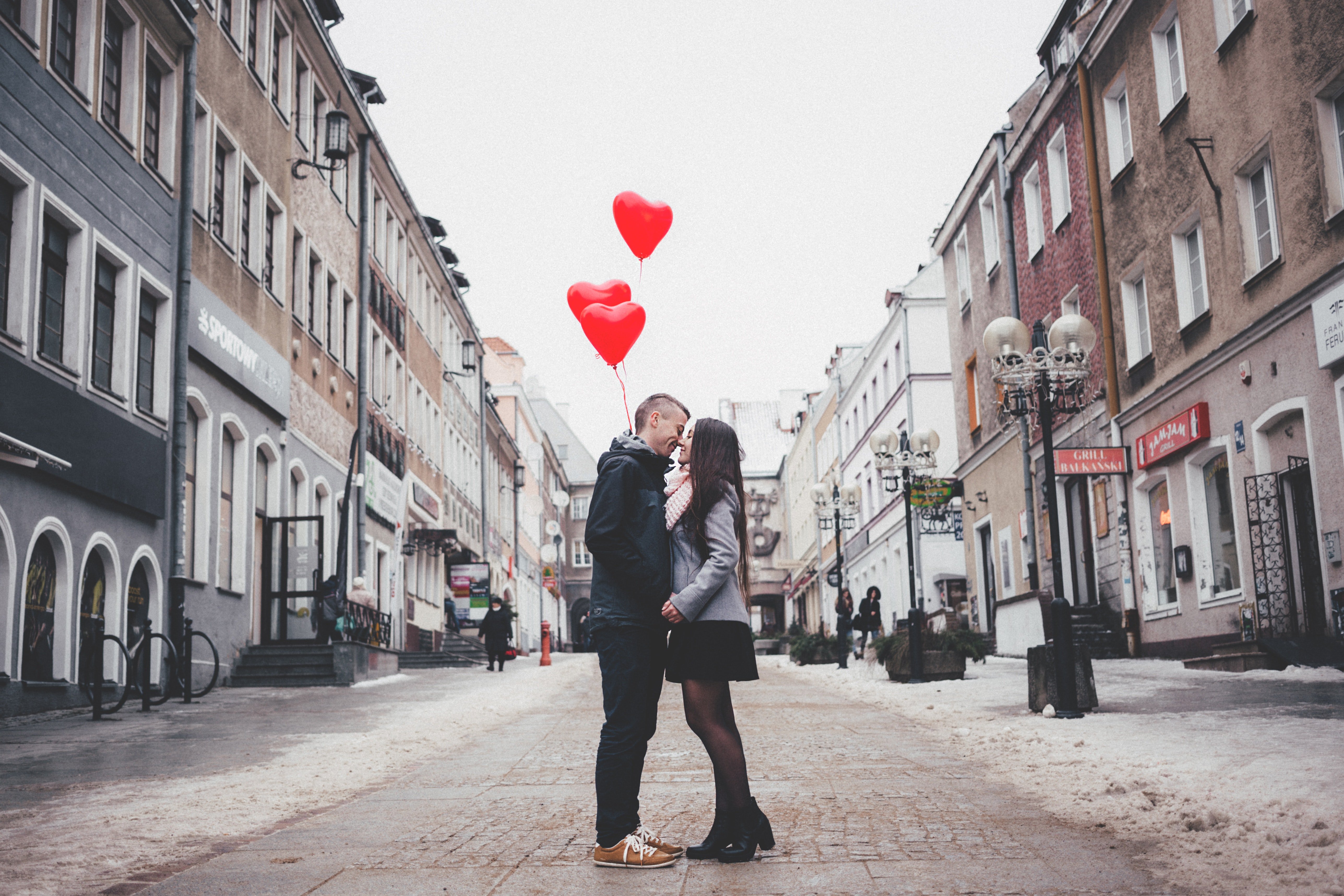 man and woman balloons kissing