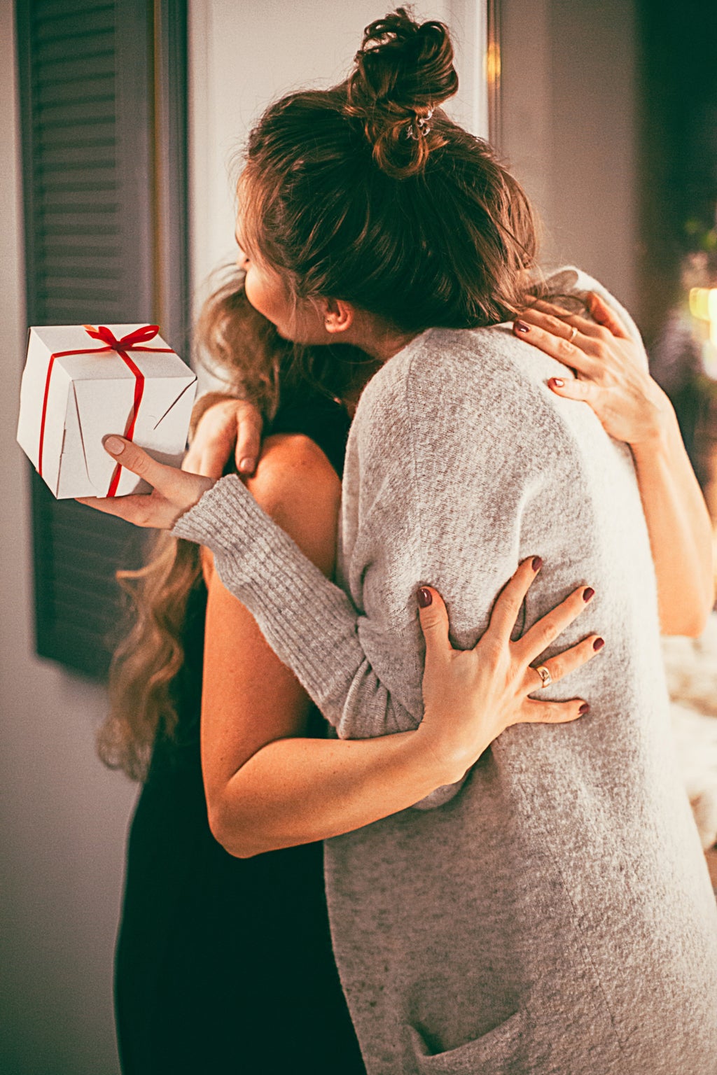 two women hugging with gift