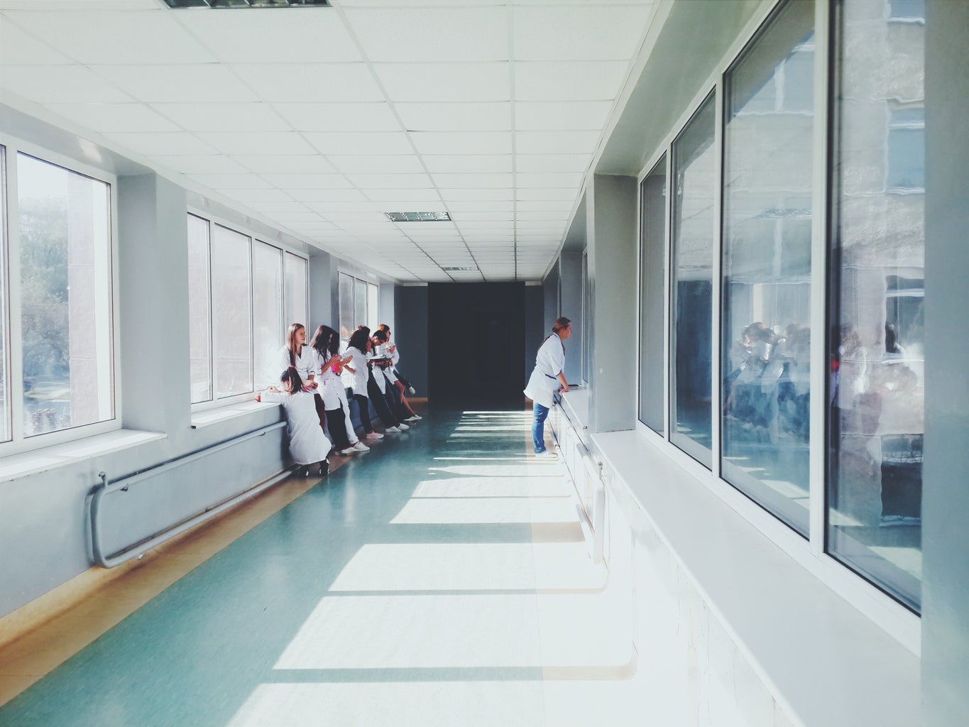 There are doctors standing in the hallway of a hospital.