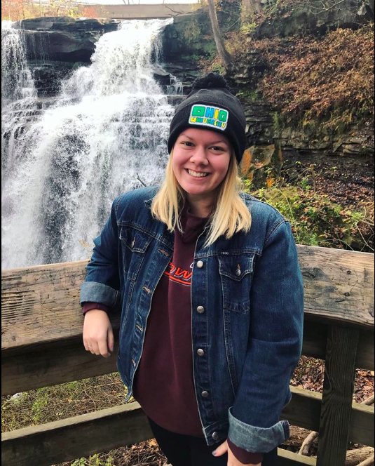 Hannah Moskowitz posing in front of a waterfall