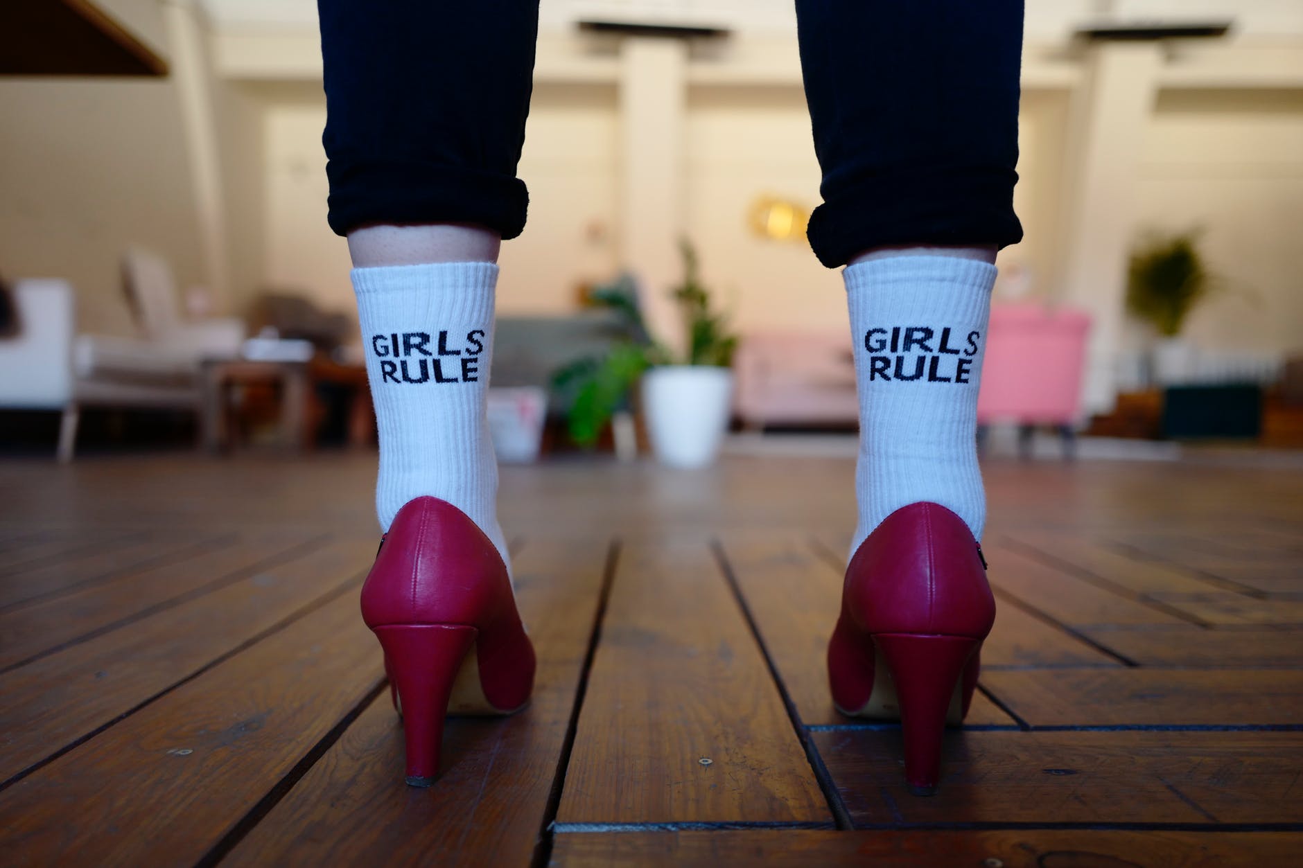 woman wearing red high heels with white socks that say girls rule