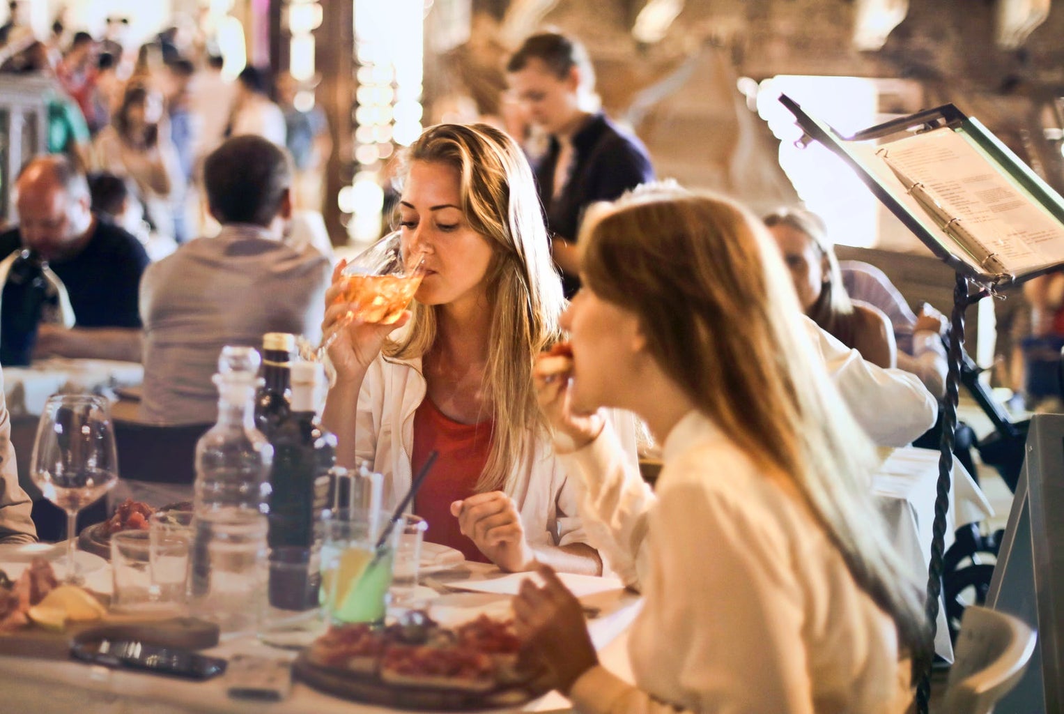 women eating and drinking wine in a restaurant