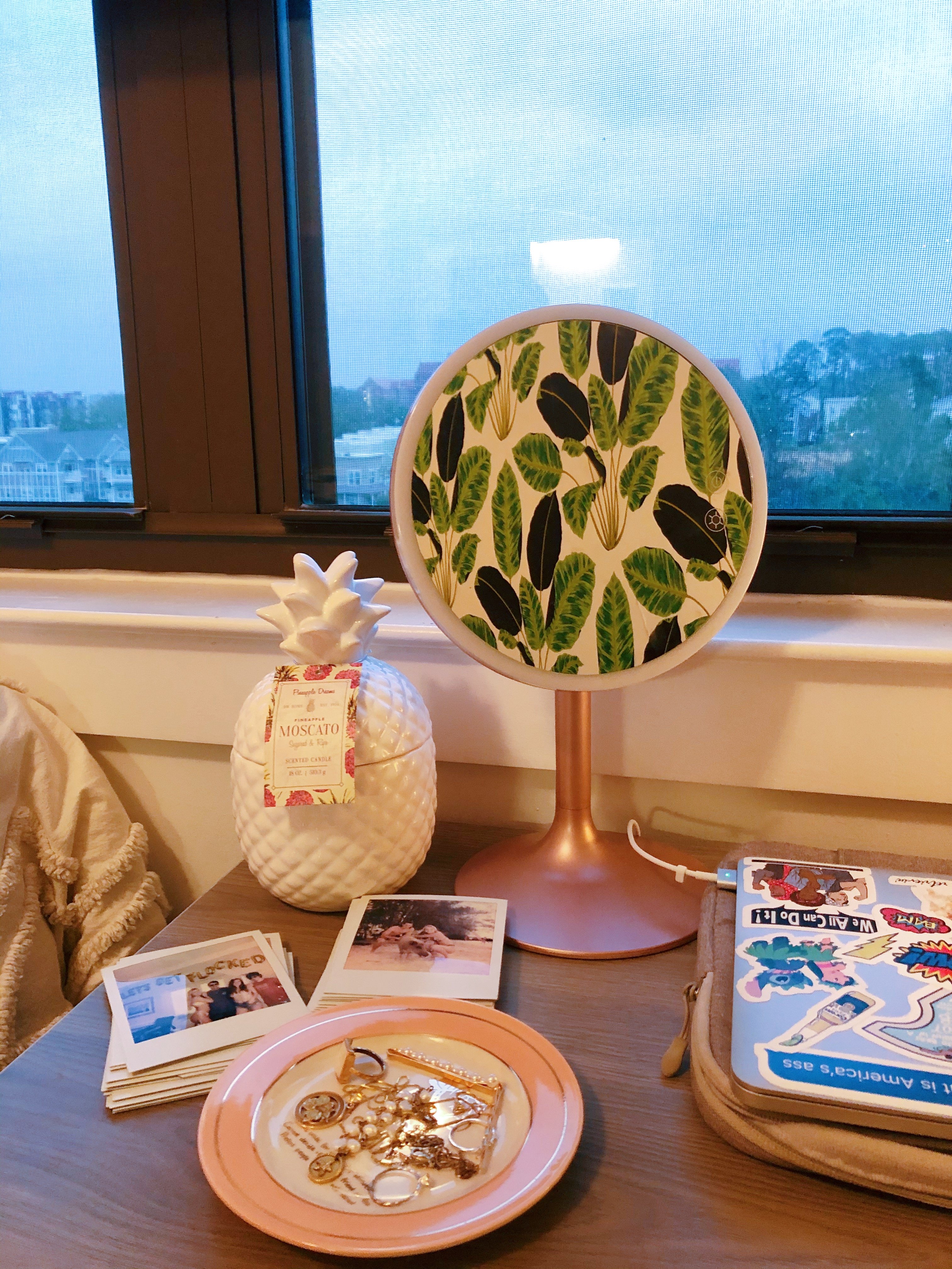 Small mirror and jewelry arranged on desk in bedroom