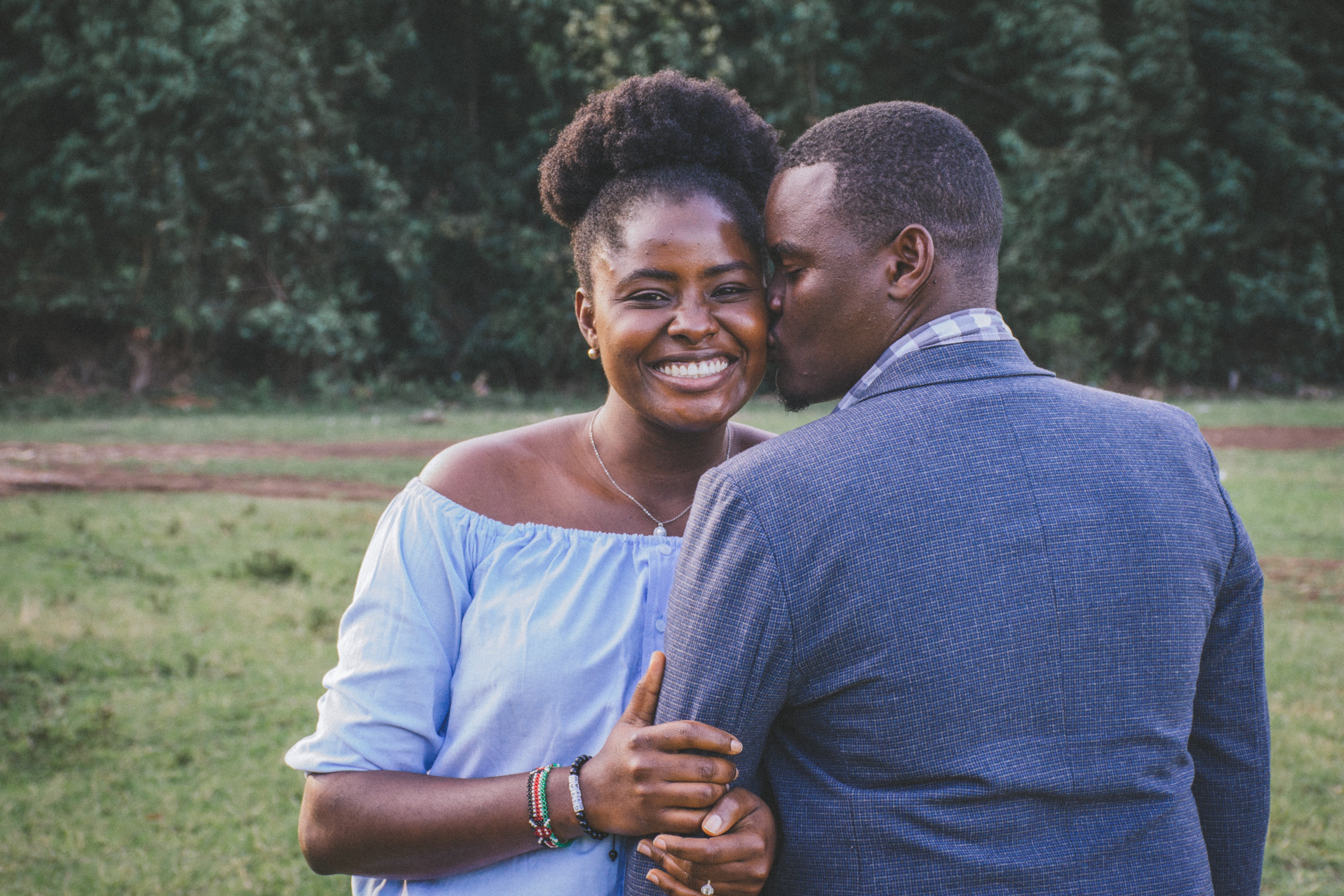 A black couple poses for the camera smiling