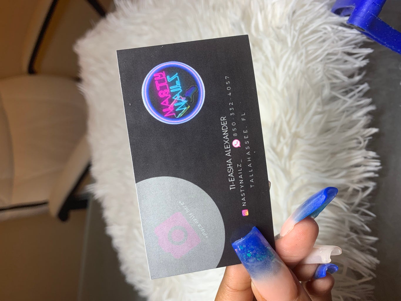 blue nails holding business card