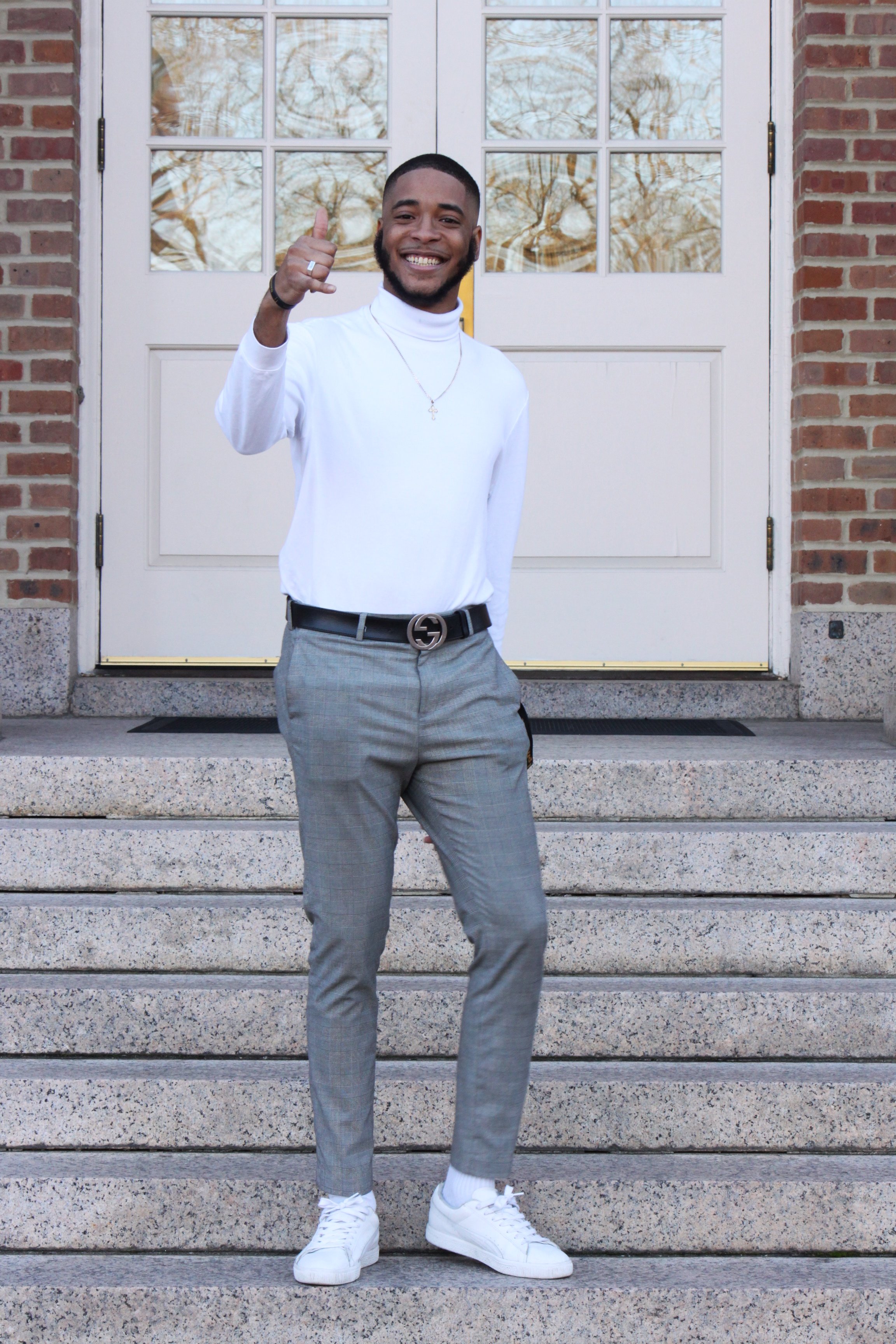 The man is holding up a sign for his fraternity.