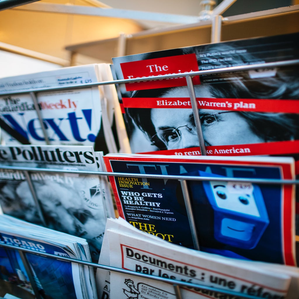 News magazine covers on a rack, including Time and The Economist
