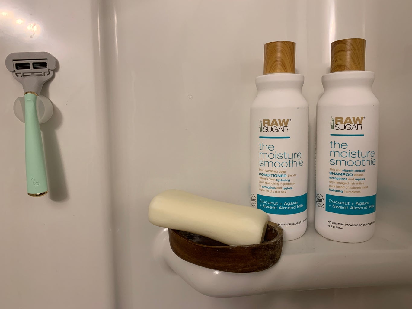 Shampoo, conditioner, bar of soap and razor in shower