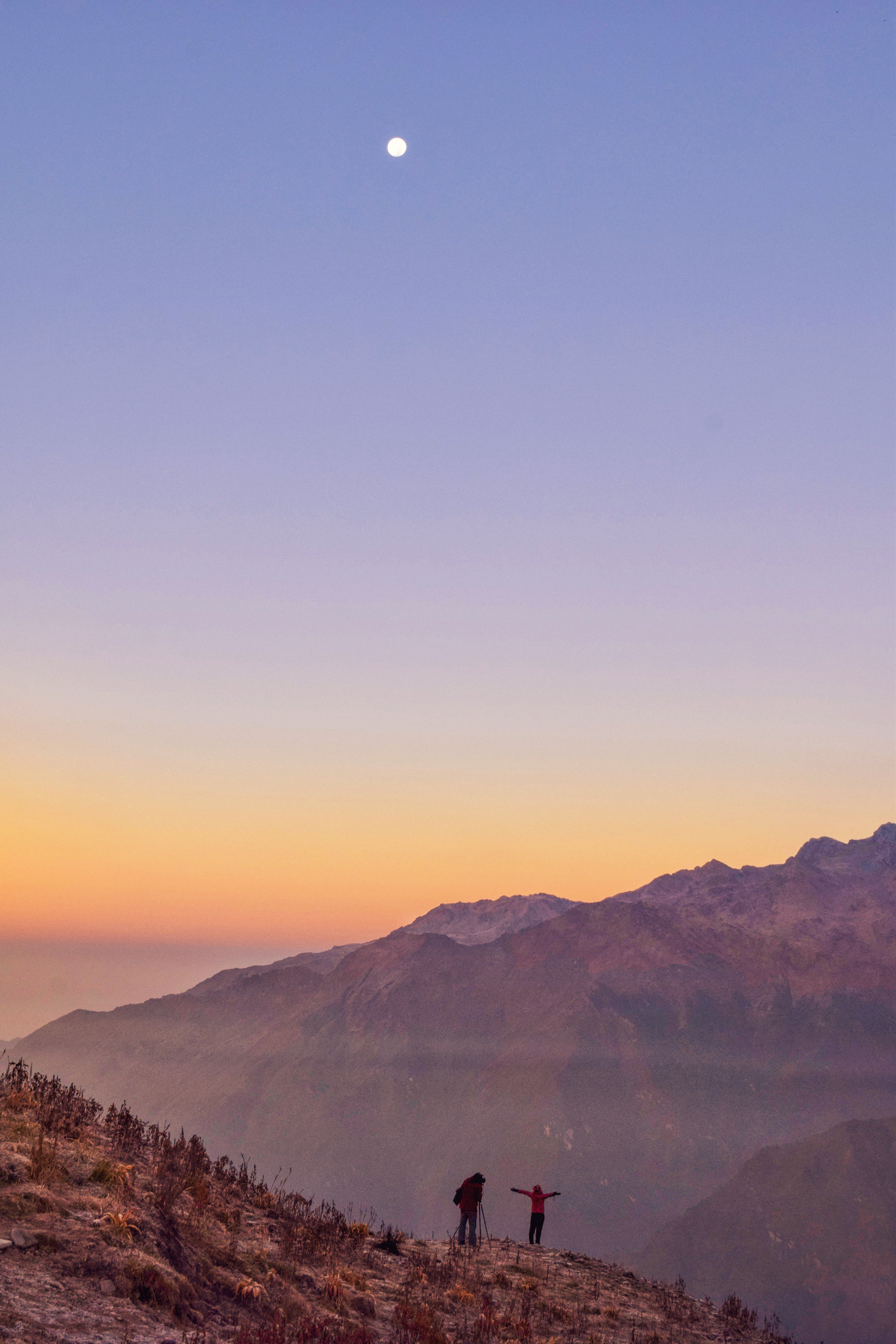 people standing near cliff during golden hour