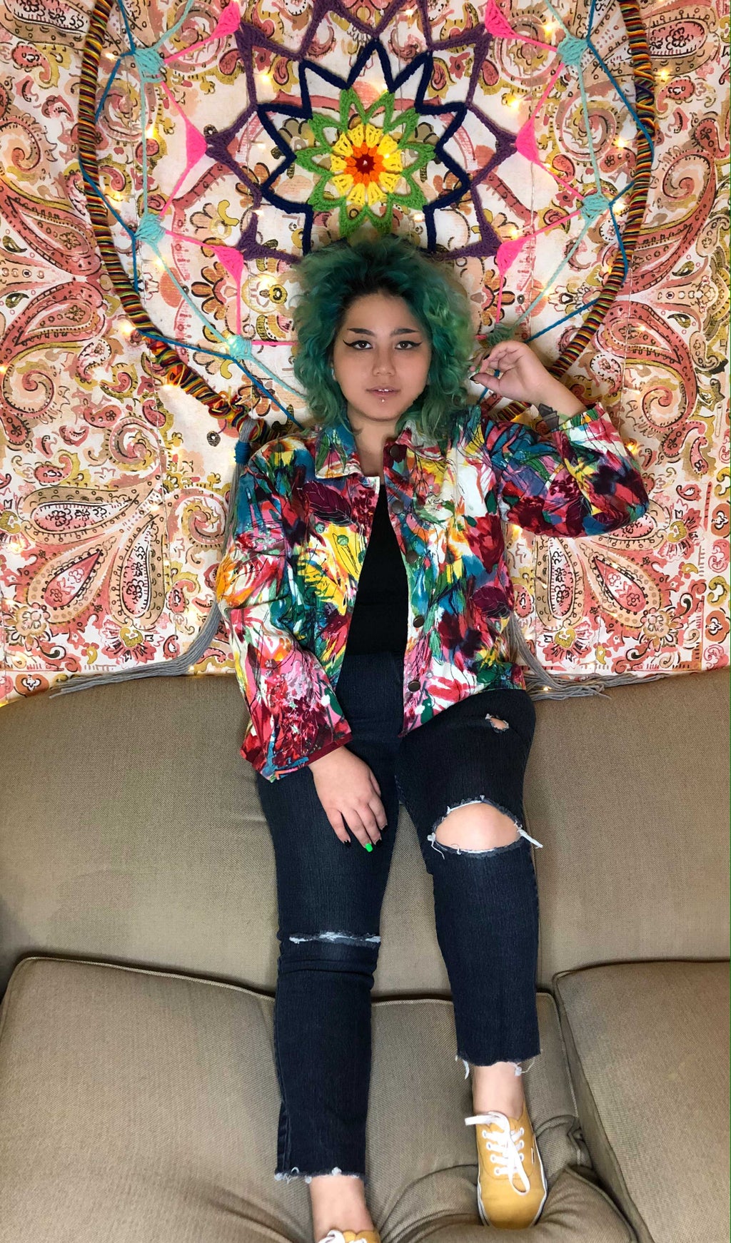 Picture I took of myself in a casual outfit in front of a tapestry