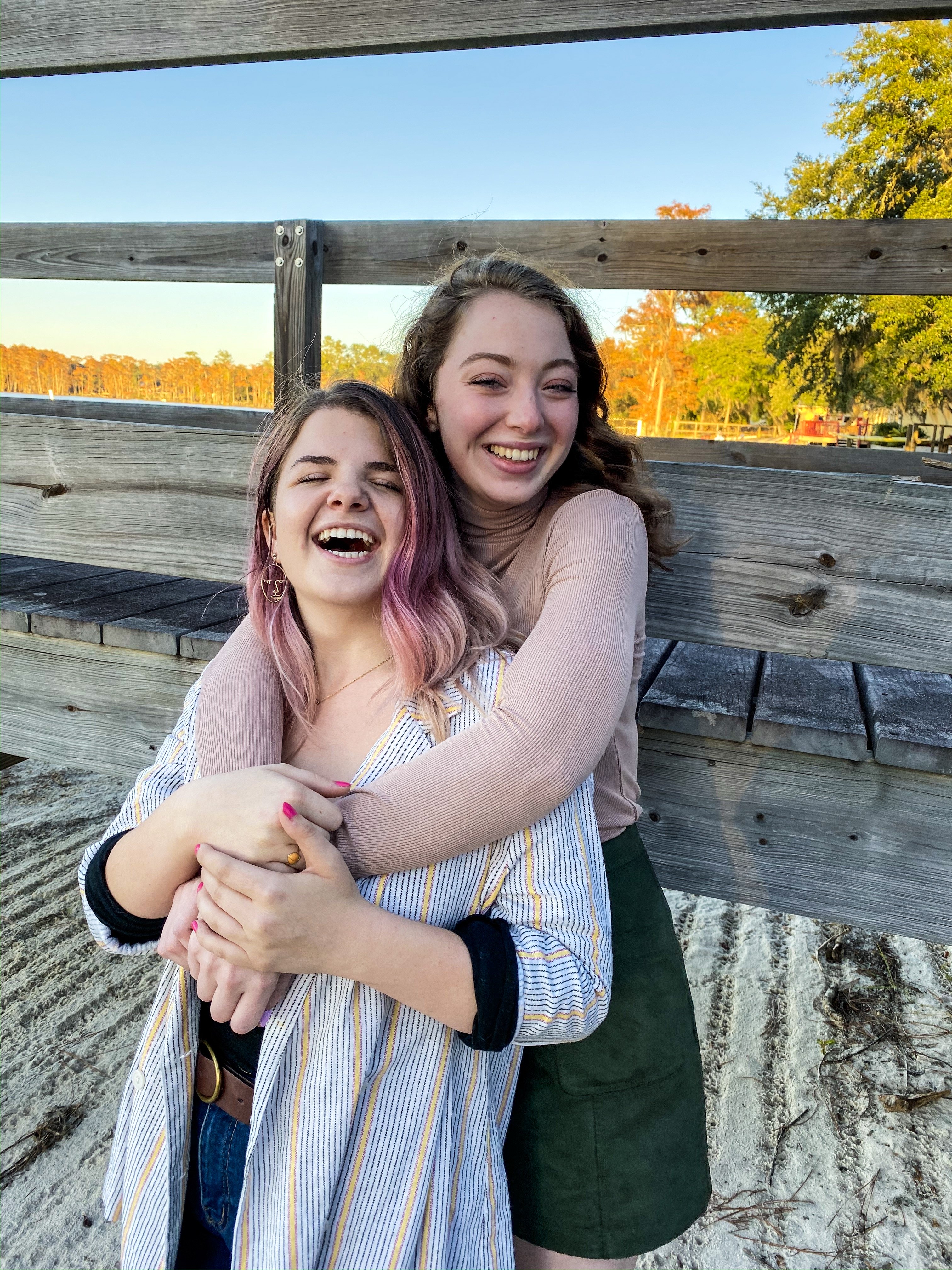 two women wrapped in a hug on the beach