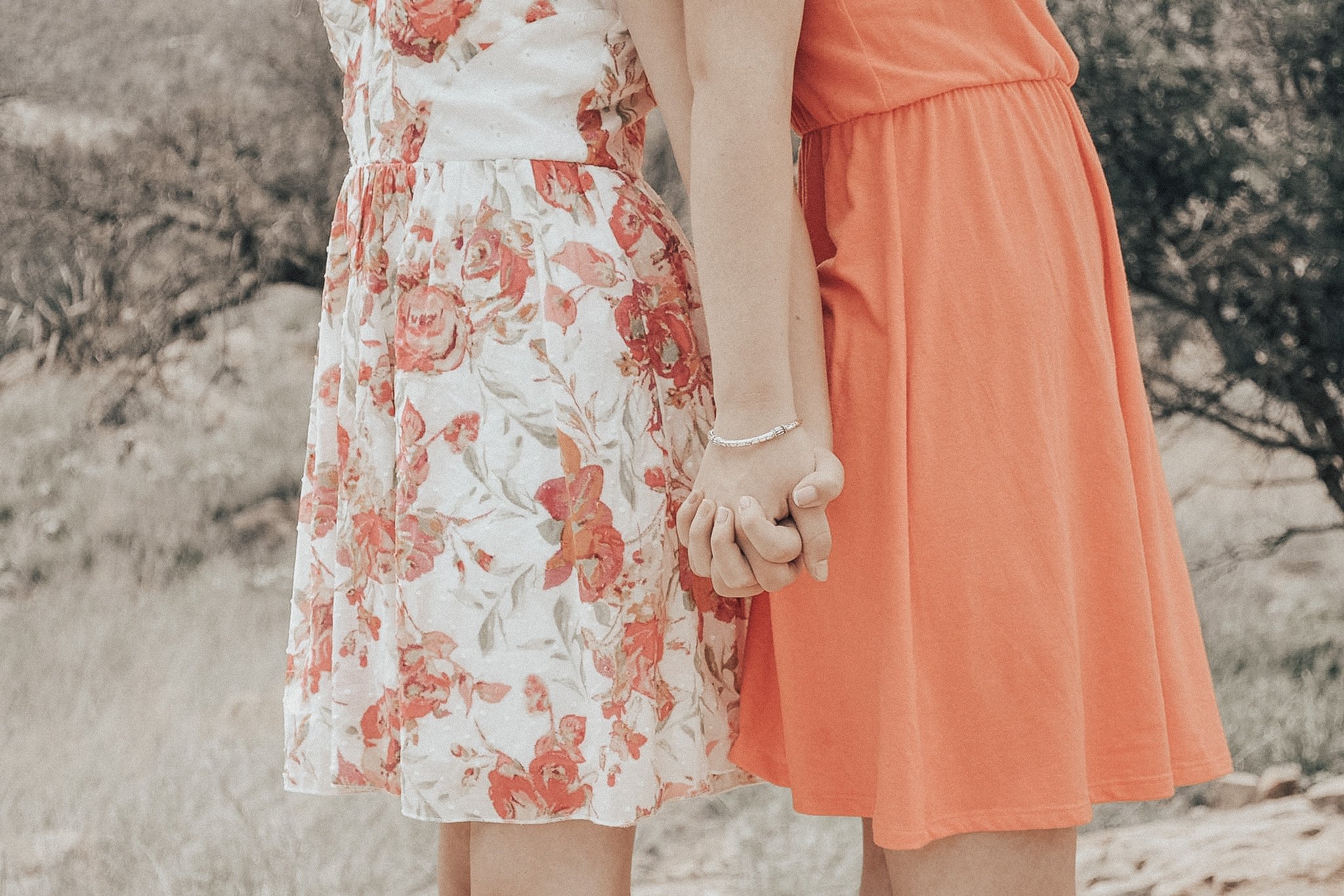 My sister and I taking pictures outside, holding hands.