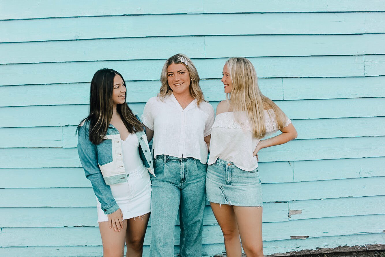 girl with two friends in front of blue wall