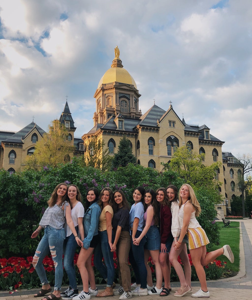 Friends standing in front of the Golden Dome at Notre Dame