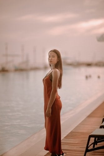 Woman in front of dock in slip dress.