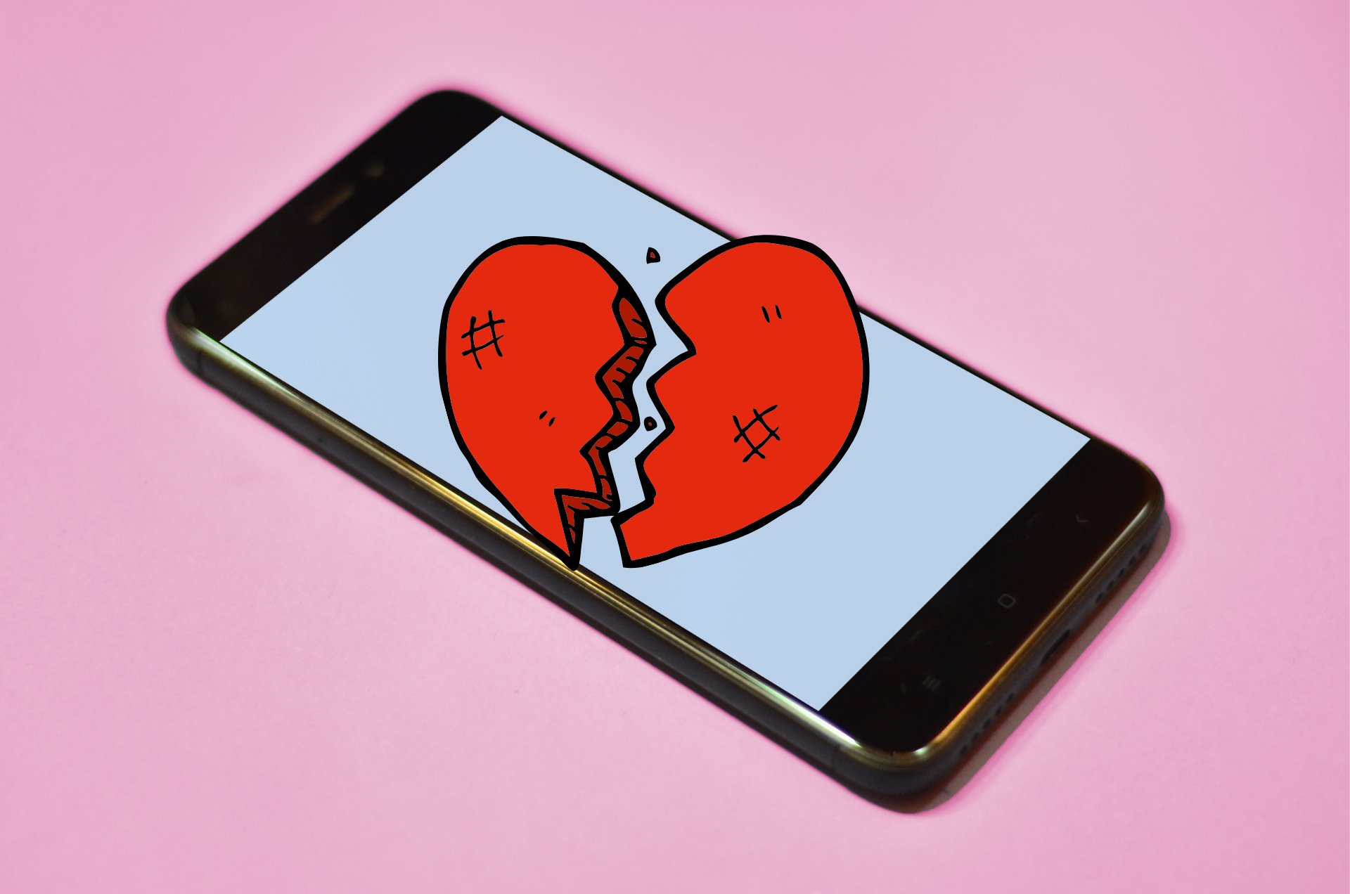 Phone with broken heart and pink background