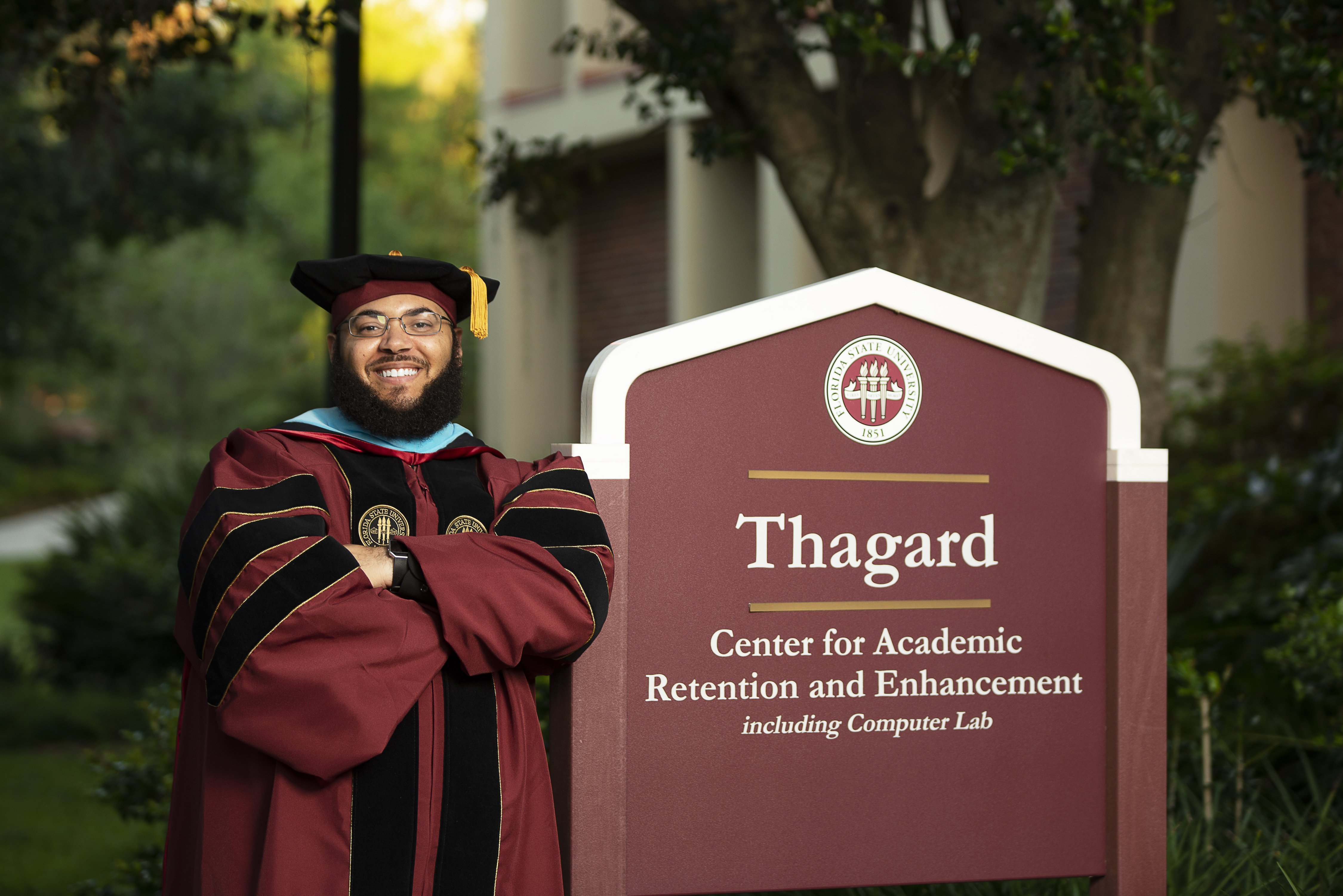 Dr. Starke leaning on \"Thagard\" sign