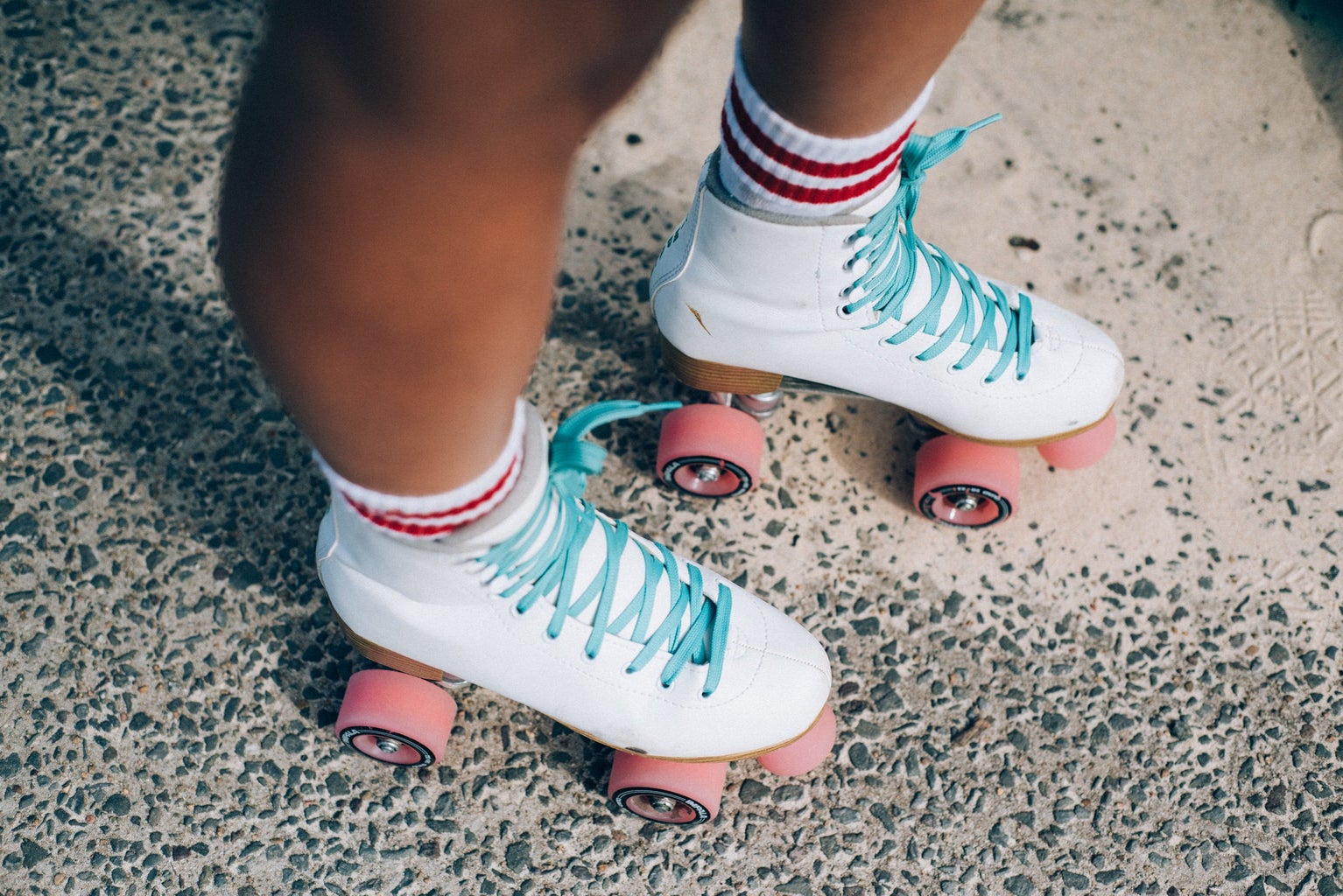 Woman wearing pink and white roller skates.
