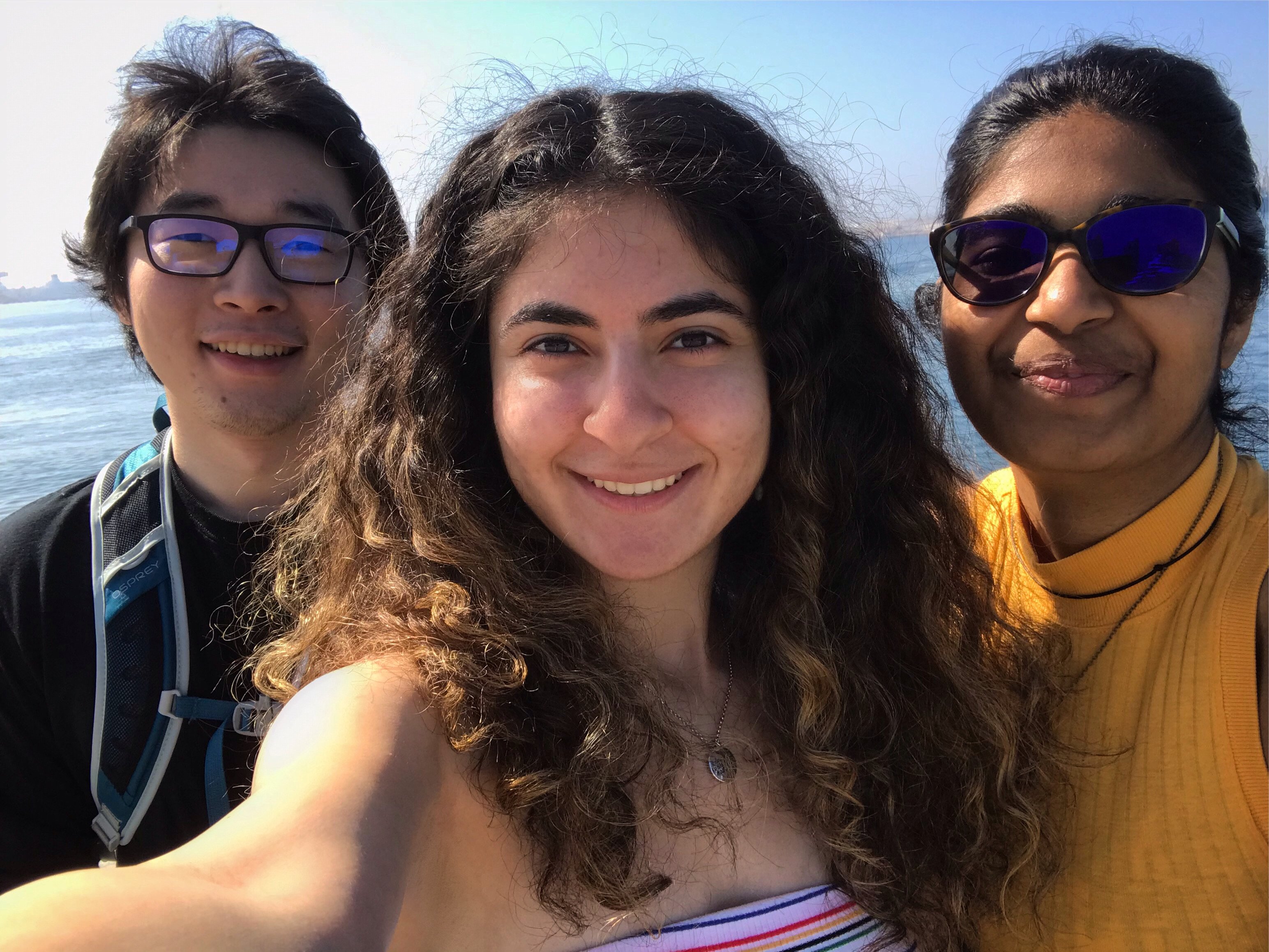 a selfie of three friends; the girl on the right has a yellow shirt