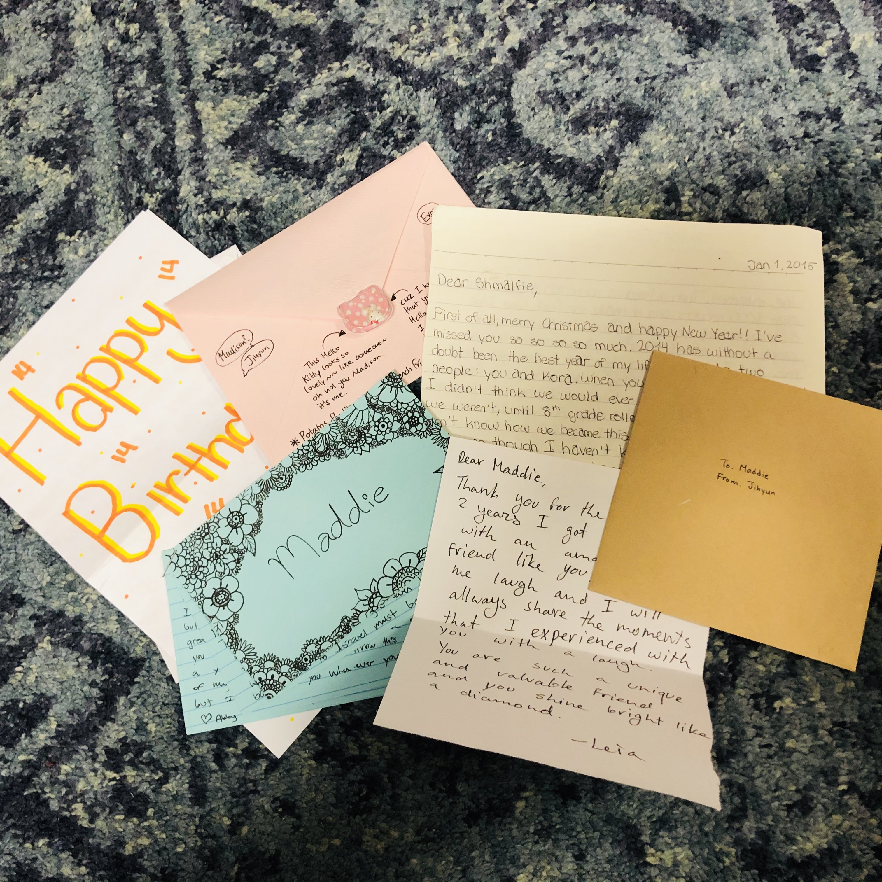 A pile of letters laid out on a carpet.