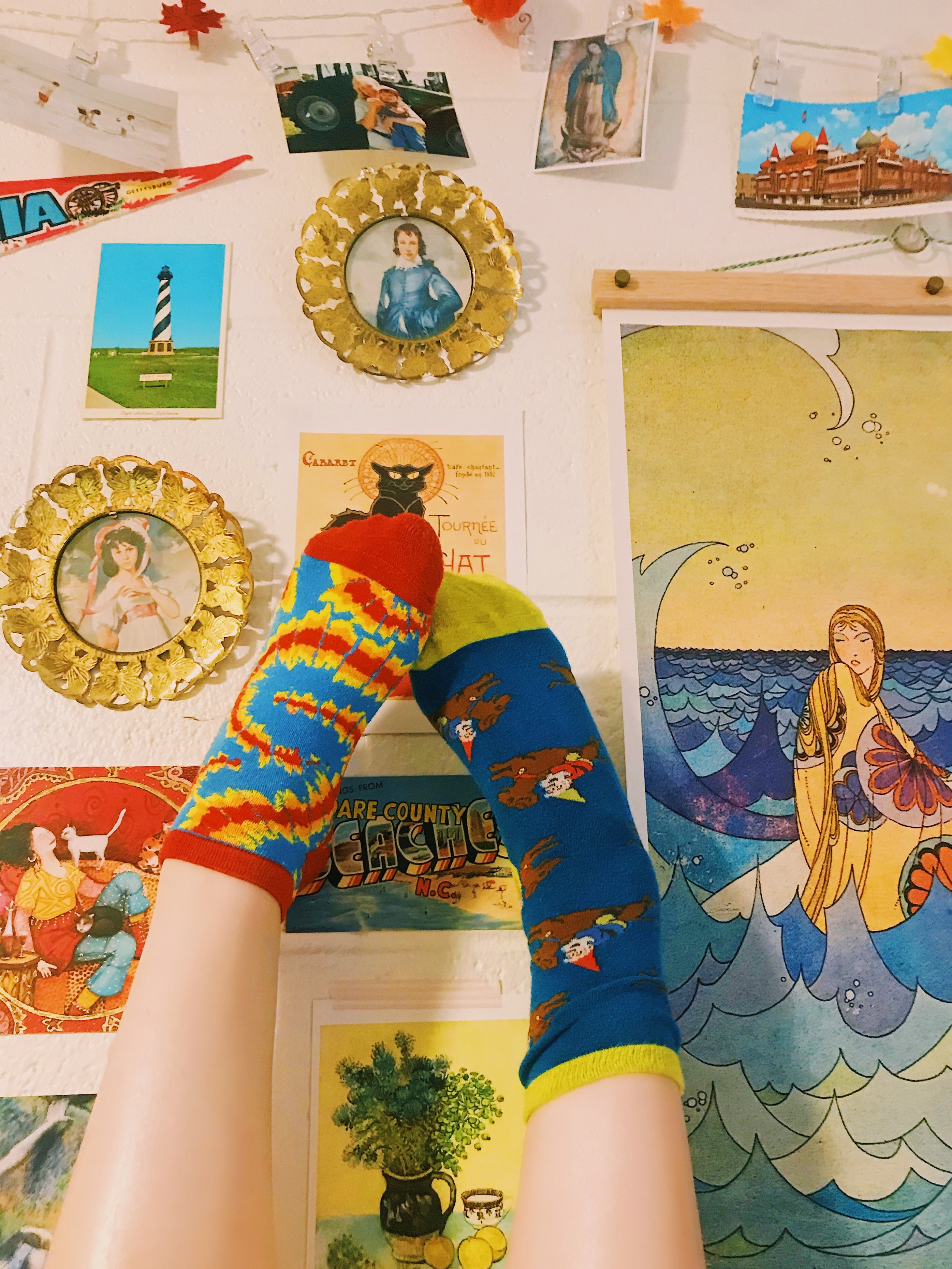 Feet in mismatched socks against photo wall