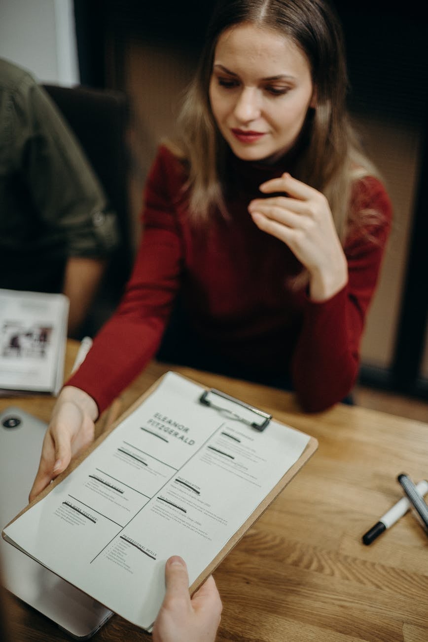 woman holding clipboard with resume on it