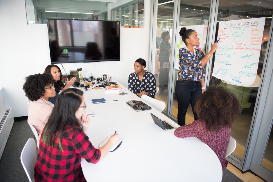 6 women working together in conference room meeting