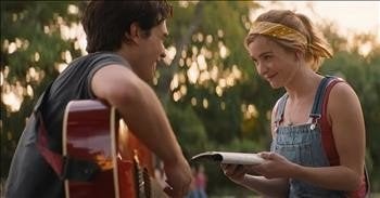 KJ Apa and Britt Robertson sitting down as their characters played in “I Still Believe.” Apa is holding a guitar and Robertson is reading a book.