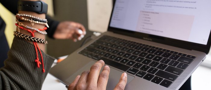 laptop, girl using it, beaded bracelets