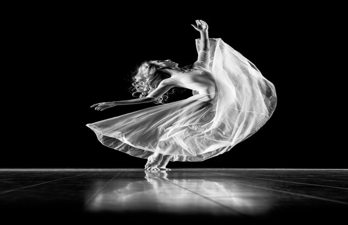 Grayscale photography of woman in long dress dancing