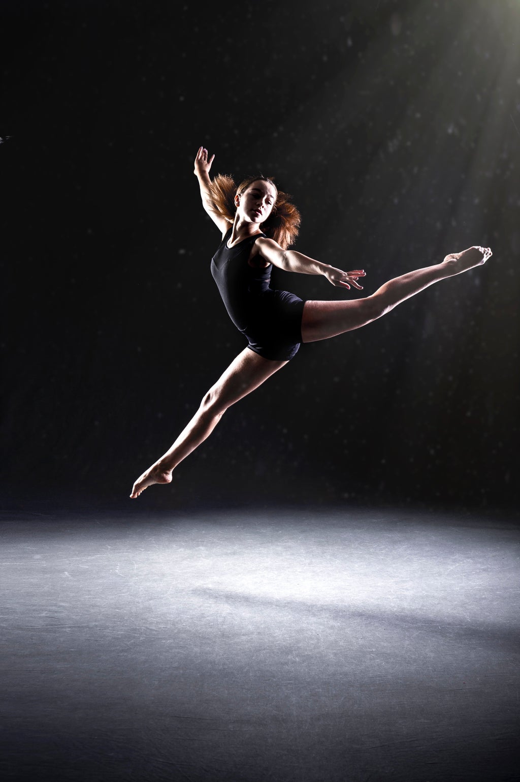 woman doing ballet against black background