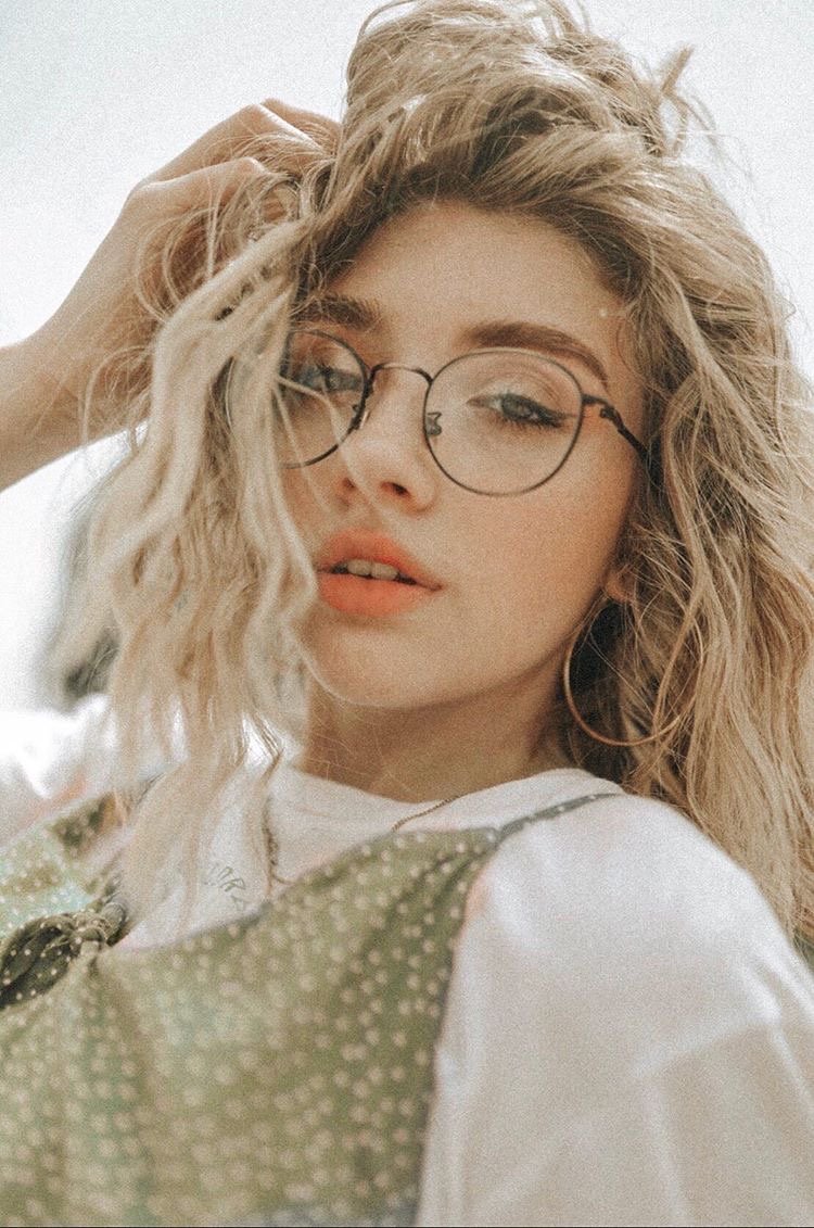 Katie Renae wearing circular glasses and a green polka dotted dress