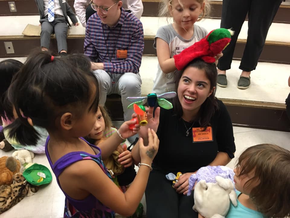 Smiling woman surrounded by young girls