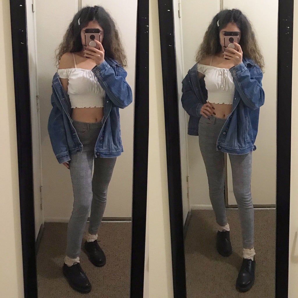 mirror selfie of a girl wearing a crop top, denim jacket, and plaid pants