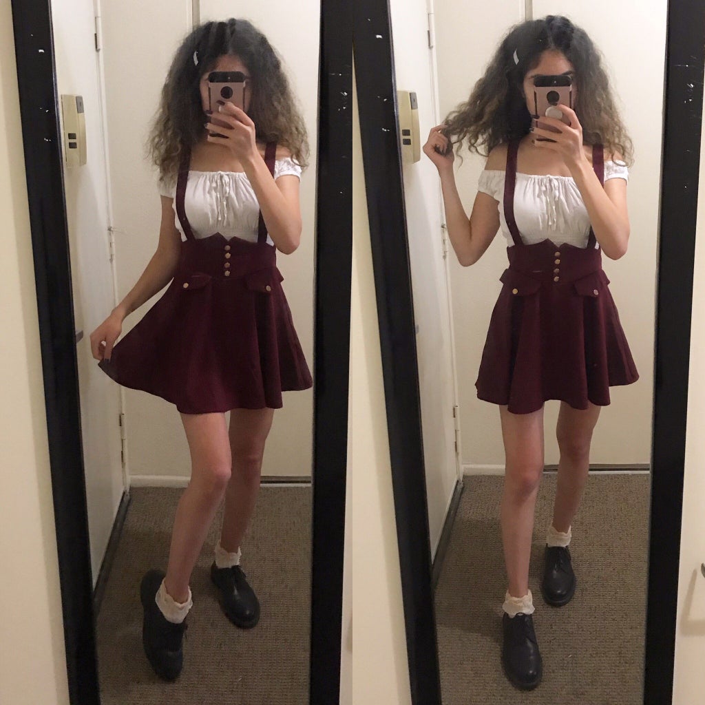 mirror selfie of a girl wearing a crop top and red pinafore skirt