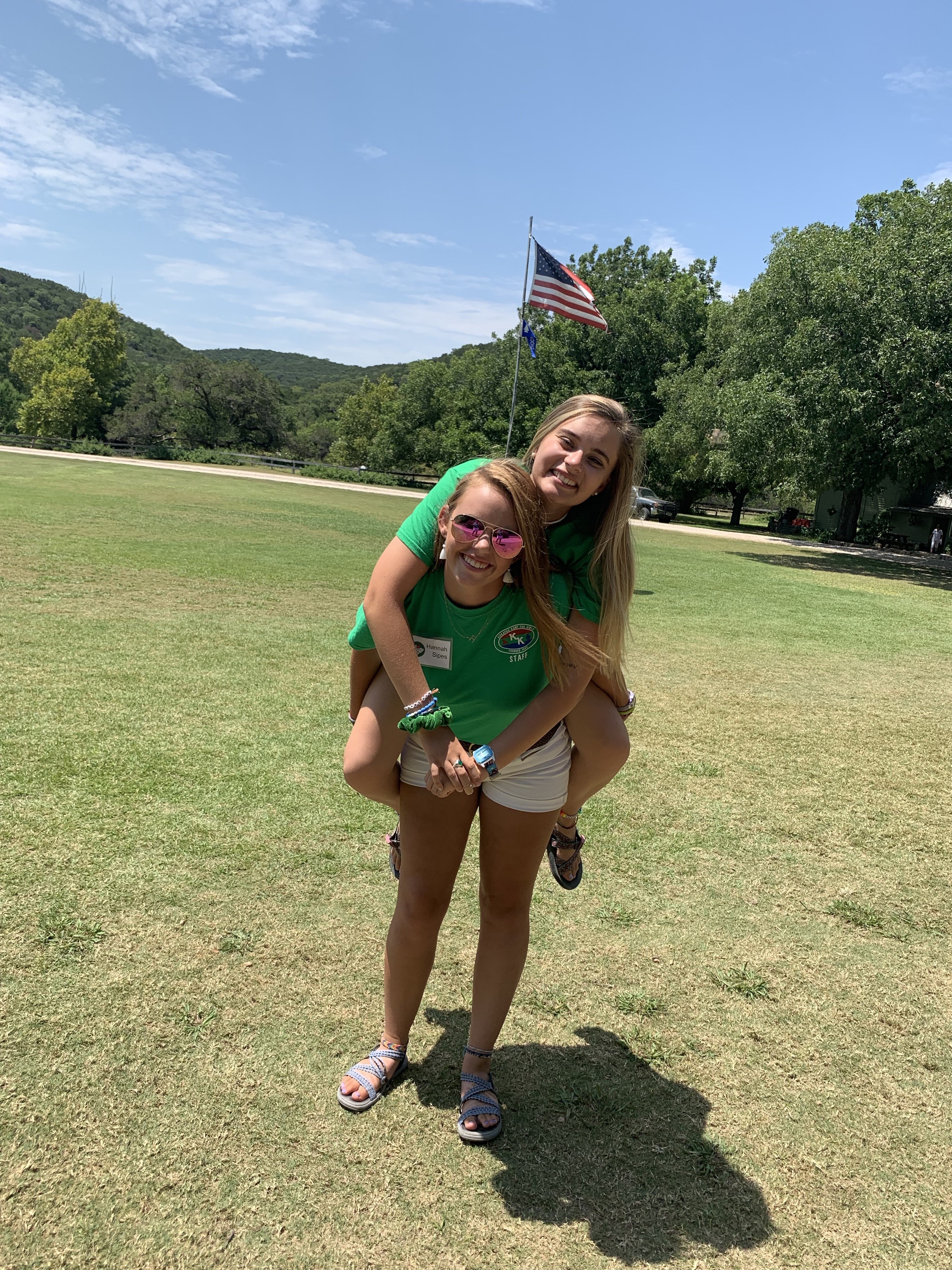 two girls in green shirt piggy back