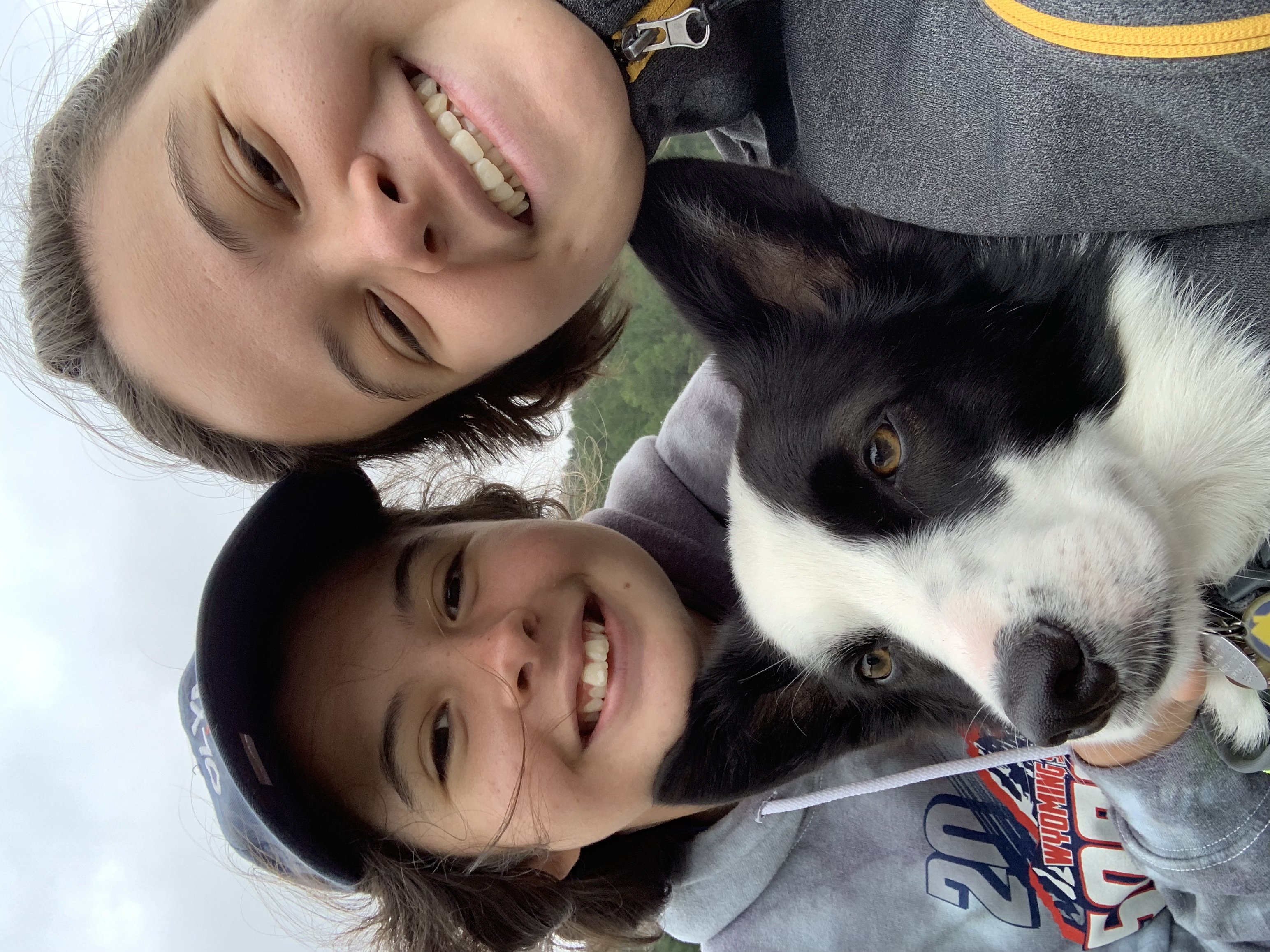 two girls with a black and white dog