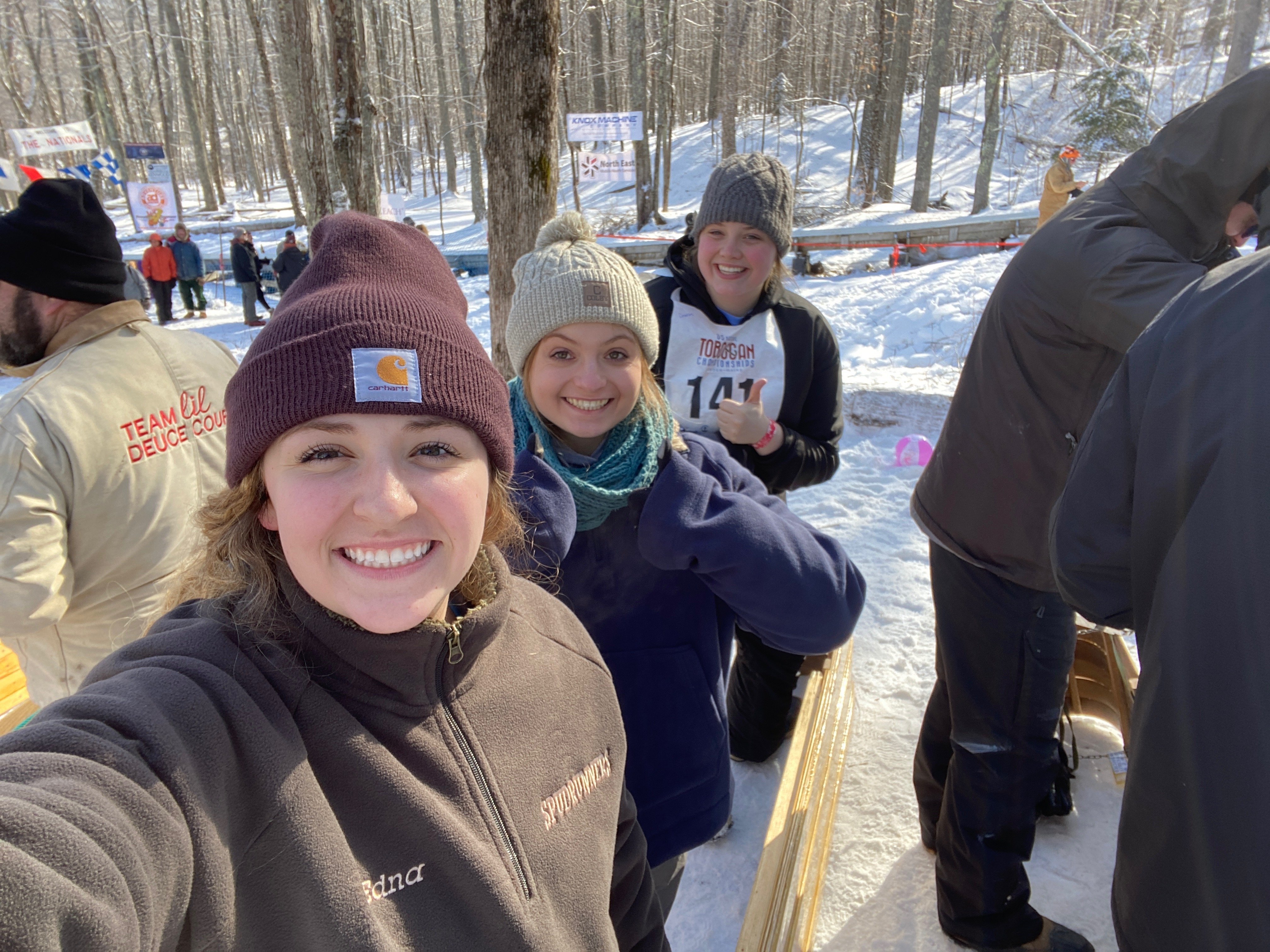 3 girls sitting in a toboggan