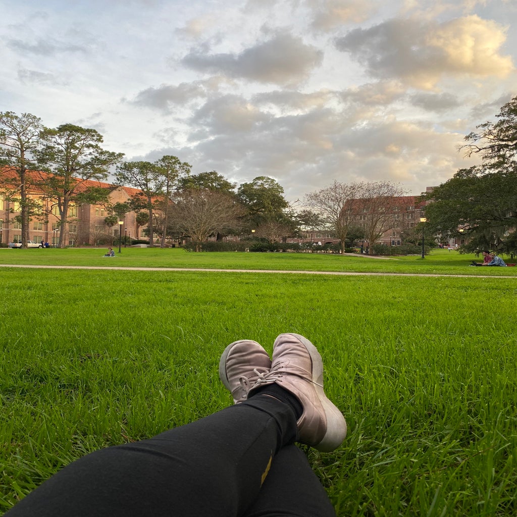 I am laying on Landis Green with pink shoes