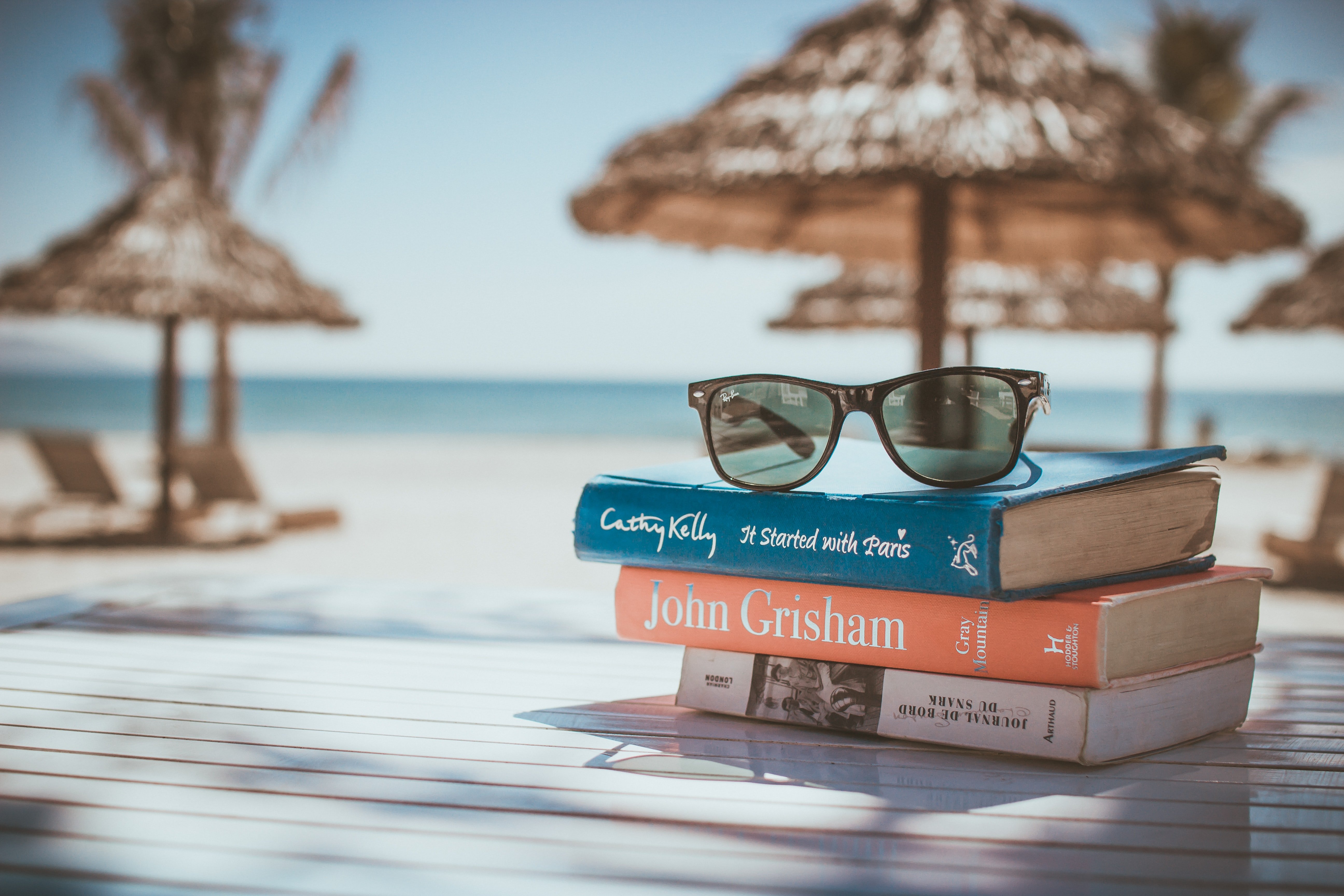 Books stacked in front of a beach