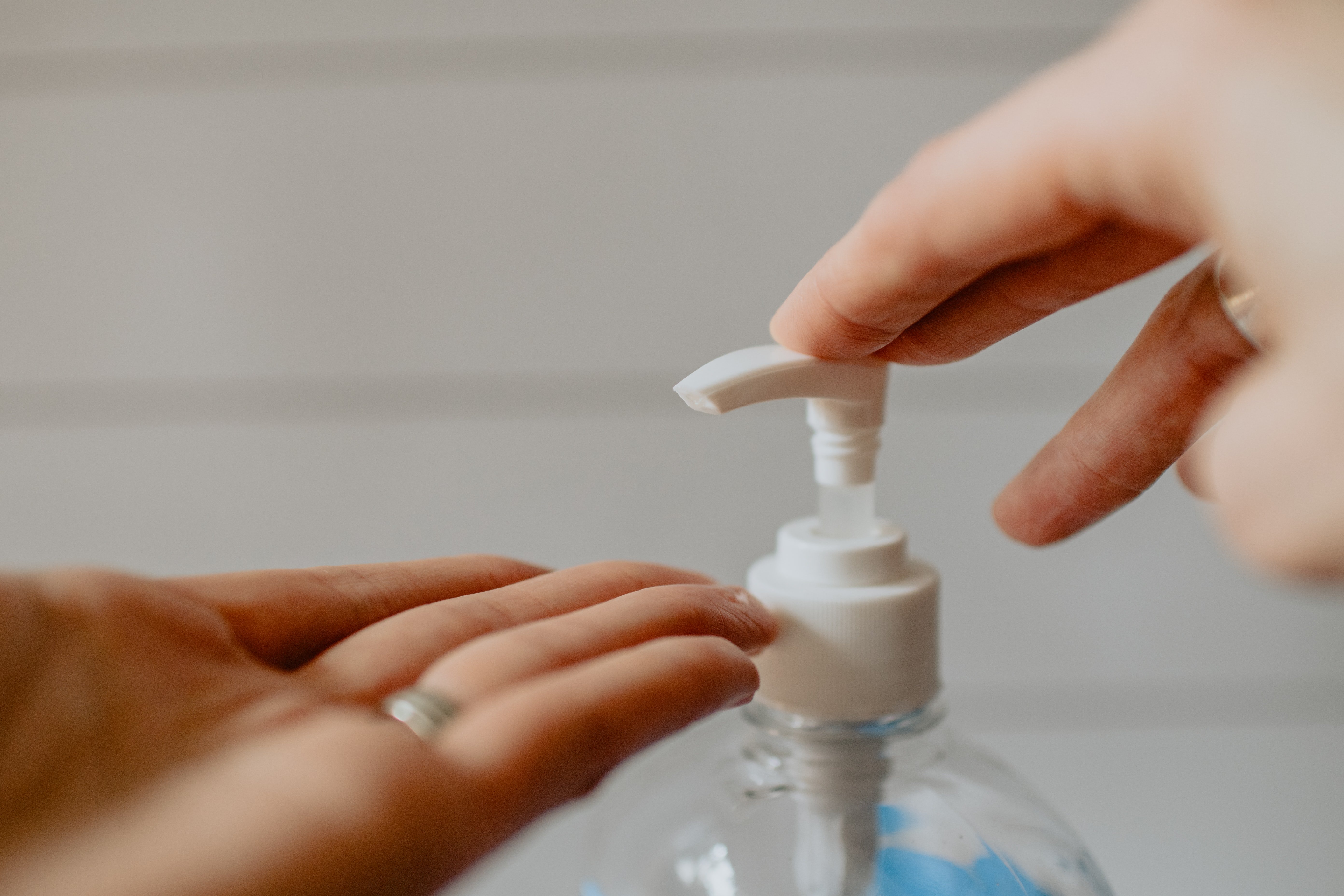 person using hand sanitizer pump