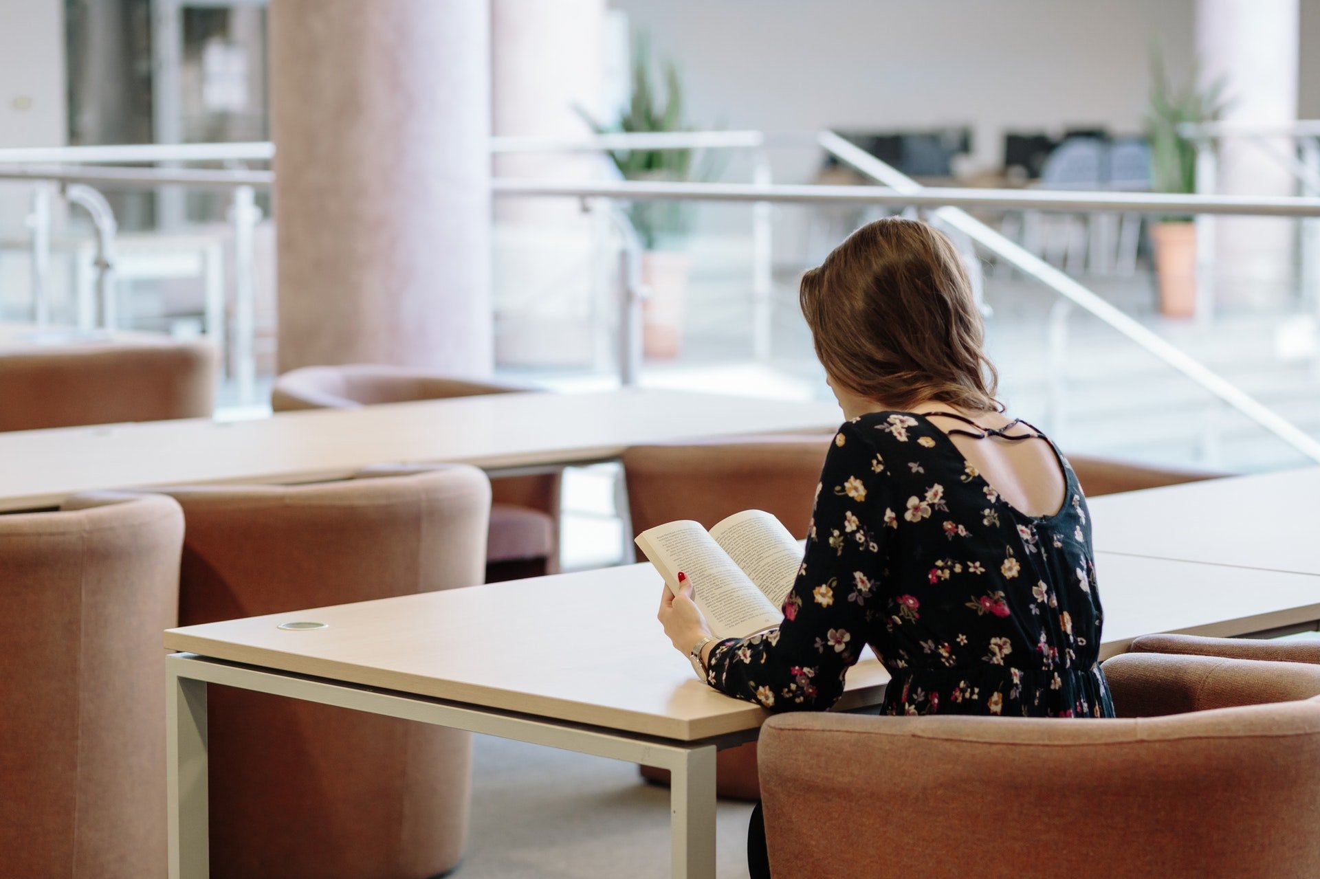 woman reading a book at a table
